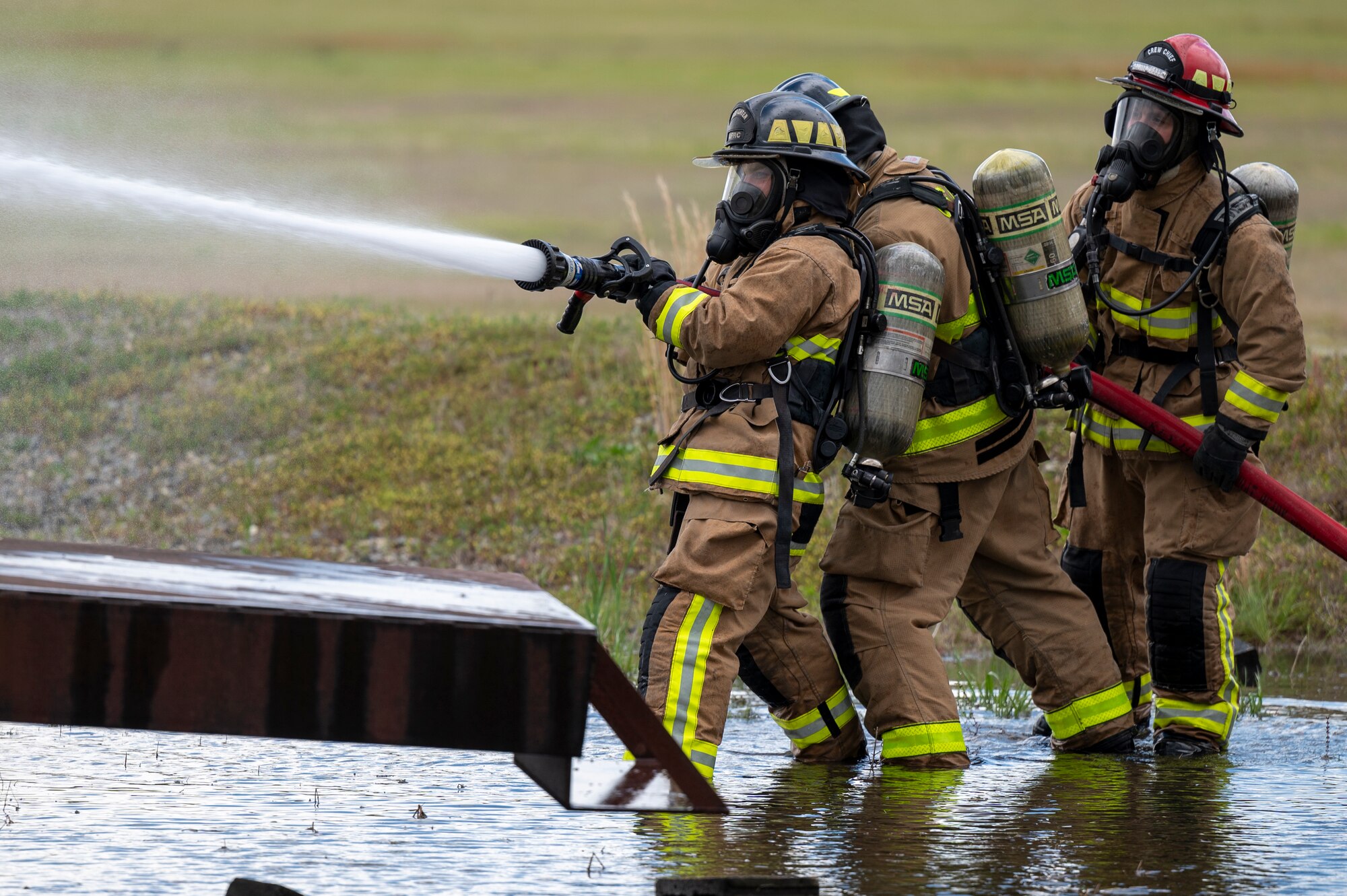 Firefighters assigned to the 4th Civil Engineer Squadron and the 916th CES use a fire hose to put out a simulated aircraft fire at Seymour Johnson Air Force Base, North Carolina, April 8, 2022.