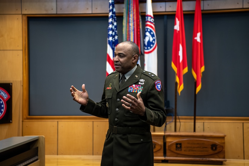 army soldiers in uniform on a stage presenting awards.