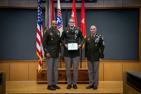 army soldiers in uniform on a stage presenting awards.