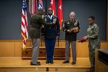 army soldiers in uniform on a stage presenting awards.