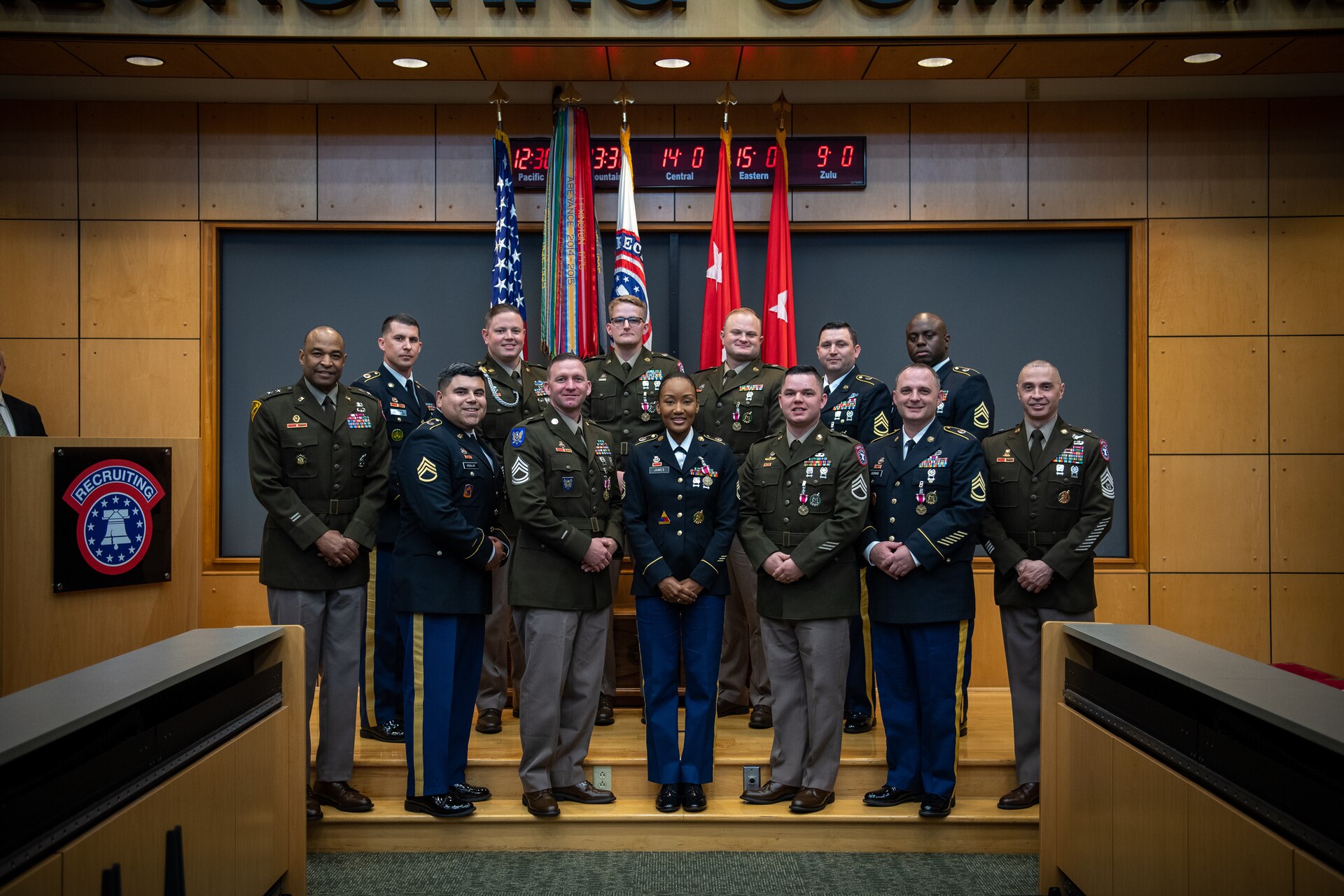 group of people wearing u.s. army uniforms posing for a photo on stage.