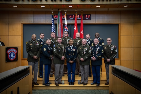 group of people wearing u.s. army uniforms posing for a photo on stage.