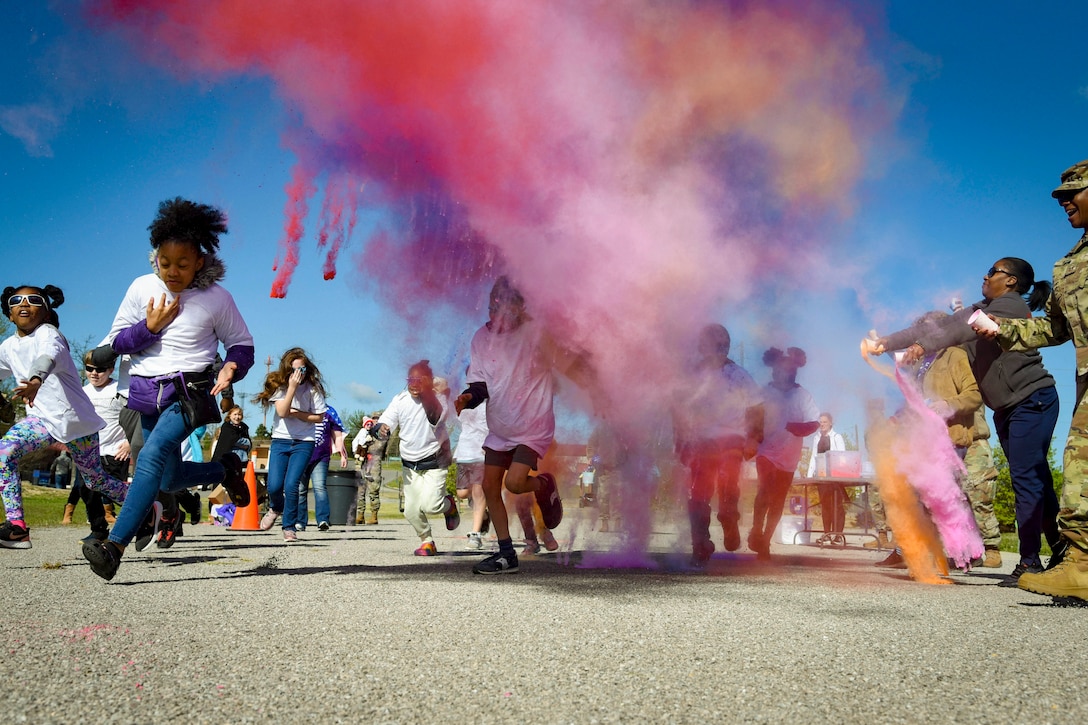 Airmen and their family members participate in a color run.