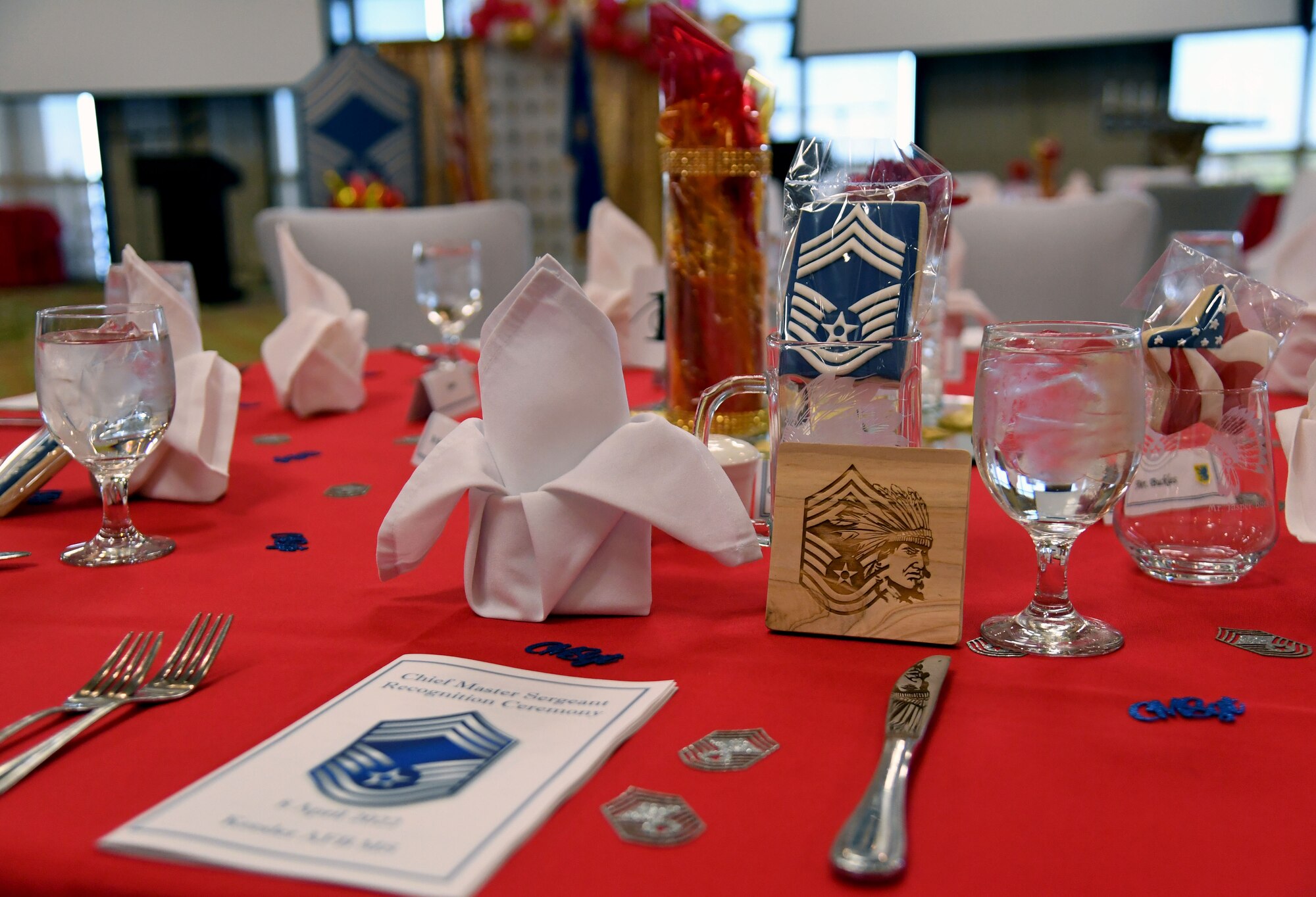 Event programs, cookies and coasters are displayed during the Chief Master Sergeant Recognition Ceremony inside the Bay Breeze Event Center at Keesler Air Force Base, Mississippi, April 8, 2022. Four Keesler Airmen earned their chief master sergeant stripe during the 2022 promotion release. Chief master sergeants make up one percent of the Air Force enlisted force. (U.S. Air Force photo by Kemberly Groue)