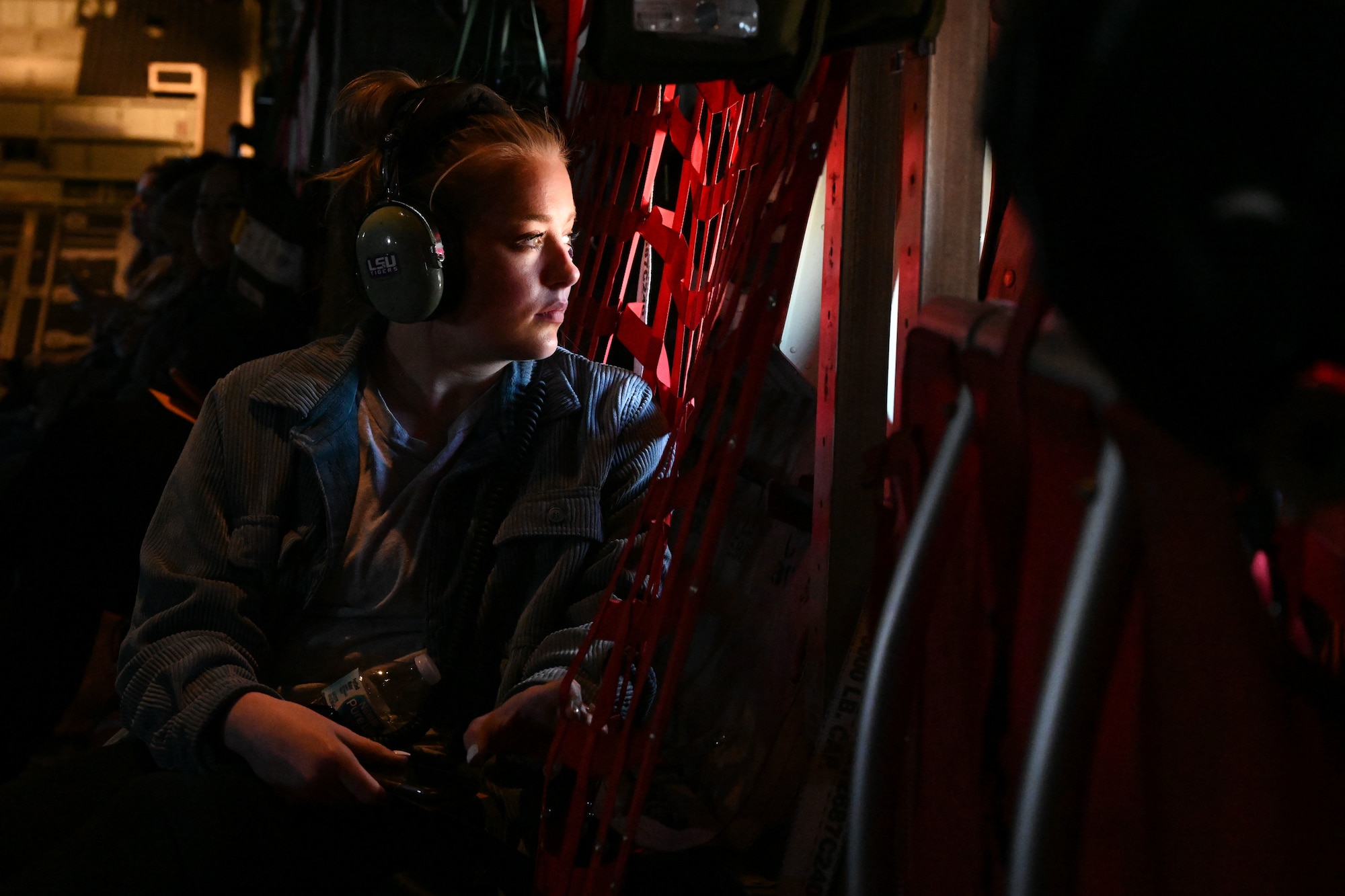 A service member’s spouse looks out the window of a C-130J Super Hercules during an orientation flight