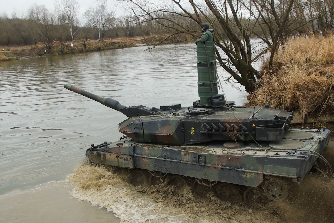 A tank crosses a river.