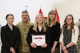 Lily Palfrey, daughter of 1st Sgt. Frank Palfrey, receives the 2020 National Guard Bureau Youth Volunteer Award during a ceremony at the 28th Expeditionary Combat Aviation Brigade armory. Lily was named winner of the award in early-2021, while her father was deployed with the 28th ECAB. She wanted to wait until her father was home to receive the award. 1st Sgt. Palfrey is the senior enlisted leader of Headquarters and Headquarters Company, 28th ECAB.