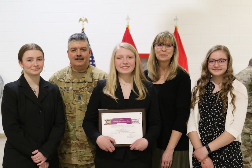 Lily Palfrey, daughter of 1st Sgt. Frank Palfrey, receives the 2020 National Guard Bureau Youth Volunteer Award during a ceremony at the 28th Expeditionary Combat Aviation Brigade armory. Lily was named winner of the award in early-2021, while her father was deployed with the 28th ECAB. She wanted to wait until her father was home to receive the award. 1st Sgt. Palfrey is the senior enlisted leader of Headquarters and Headquarters Company, 28th ECAB.