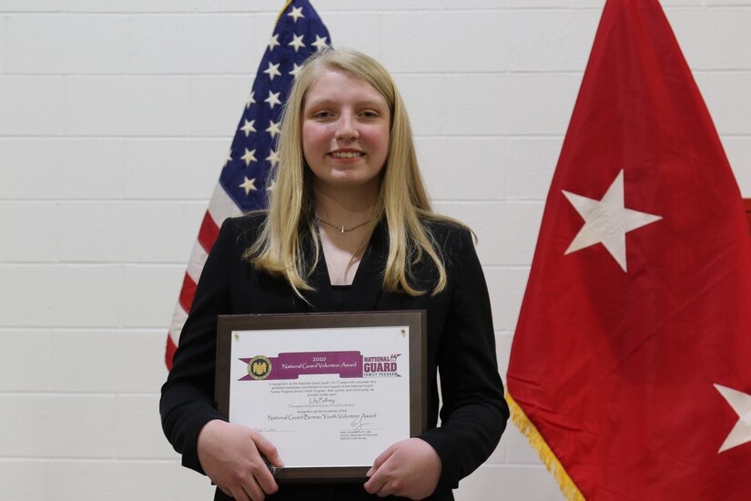 Lily Palfrey, daughter of 1st Sgt. Frank Palfrey, receives the 2020 National Guard Bureau Youth Volunteer Award during a ceremony at the 28th Expeditionary Combat Aviation Brigade armory. Lily was named winner of the award in early-2021, while her father was deployed with the 28th ECAB. She wanted to wait until her father was home to receive the award. 1st Sgt. Palfrey is the senior enlisted leader of Headquarters and Headquarters Company, 28th ECAB.