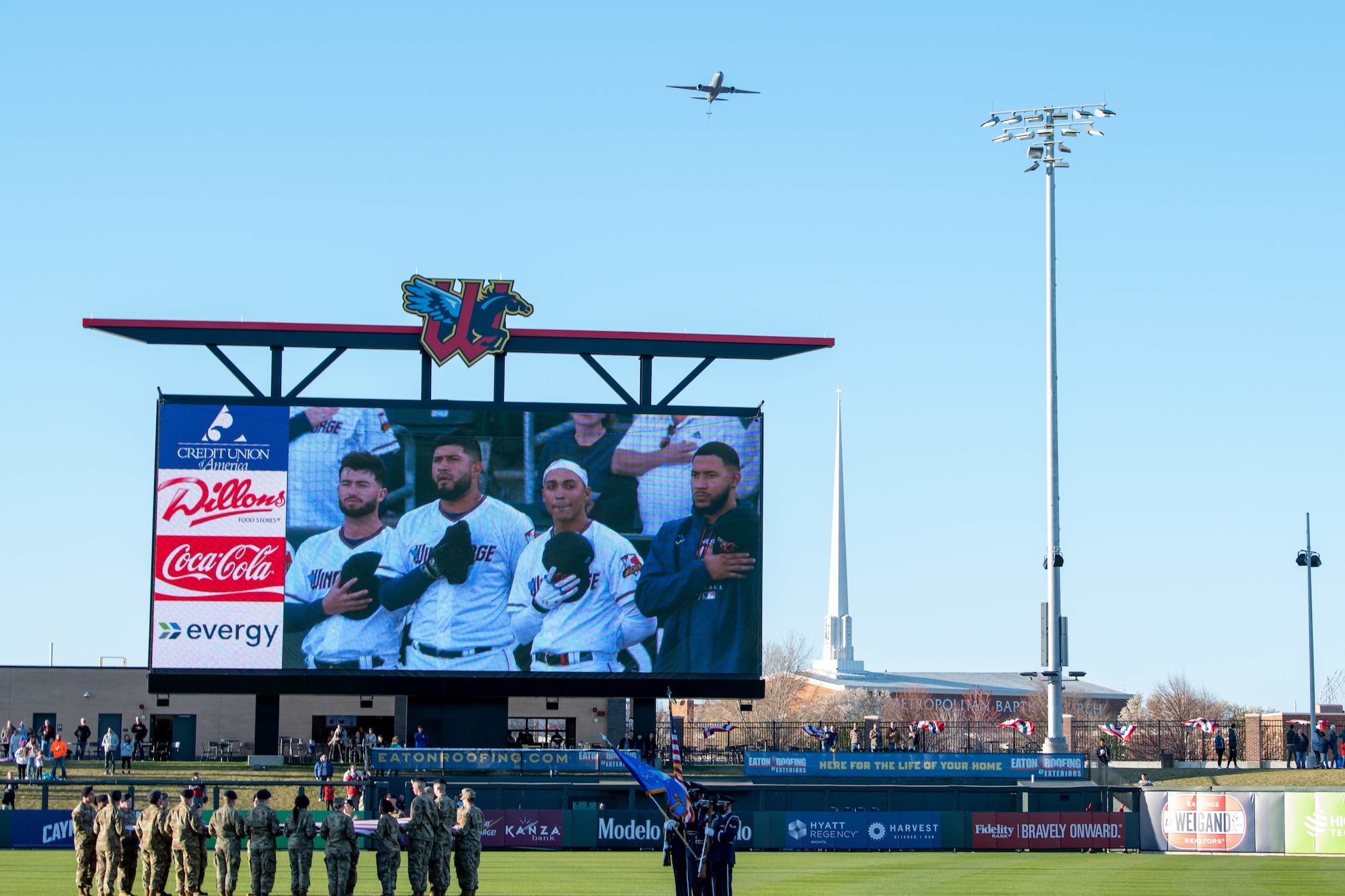 Airmen from the 344th Air Refueling Squadron, fly a KC-46 Pegasus over a Wichita Wind Surge Game during the National Anthem April 8, 2022, at Riverfront Stadium in Wichita, Kansas.