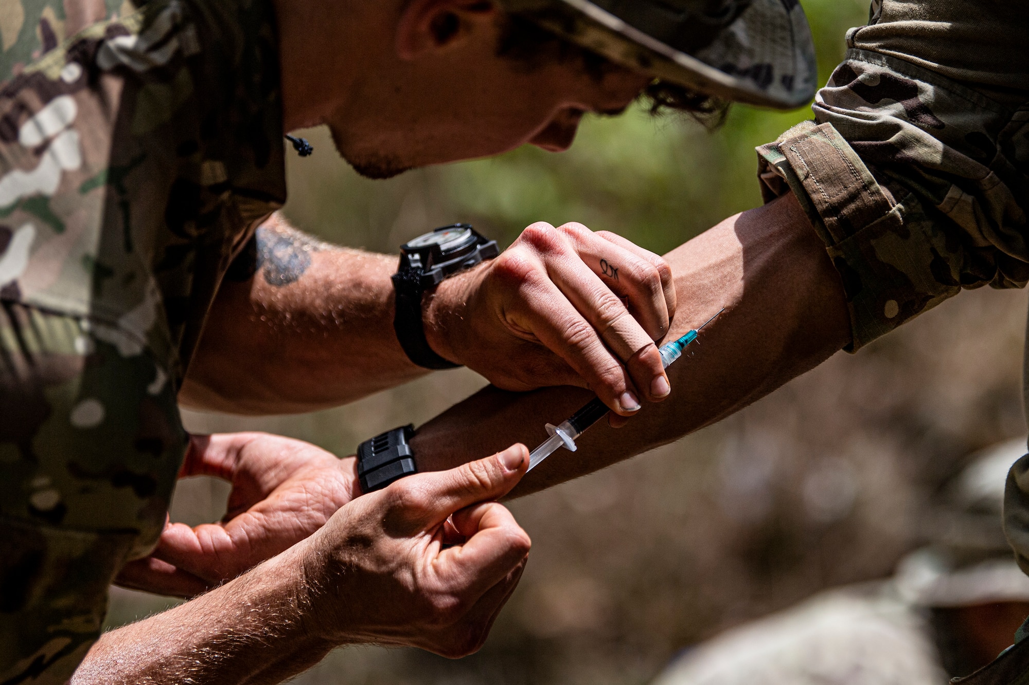 Photo of Airman drawing blood with a needle