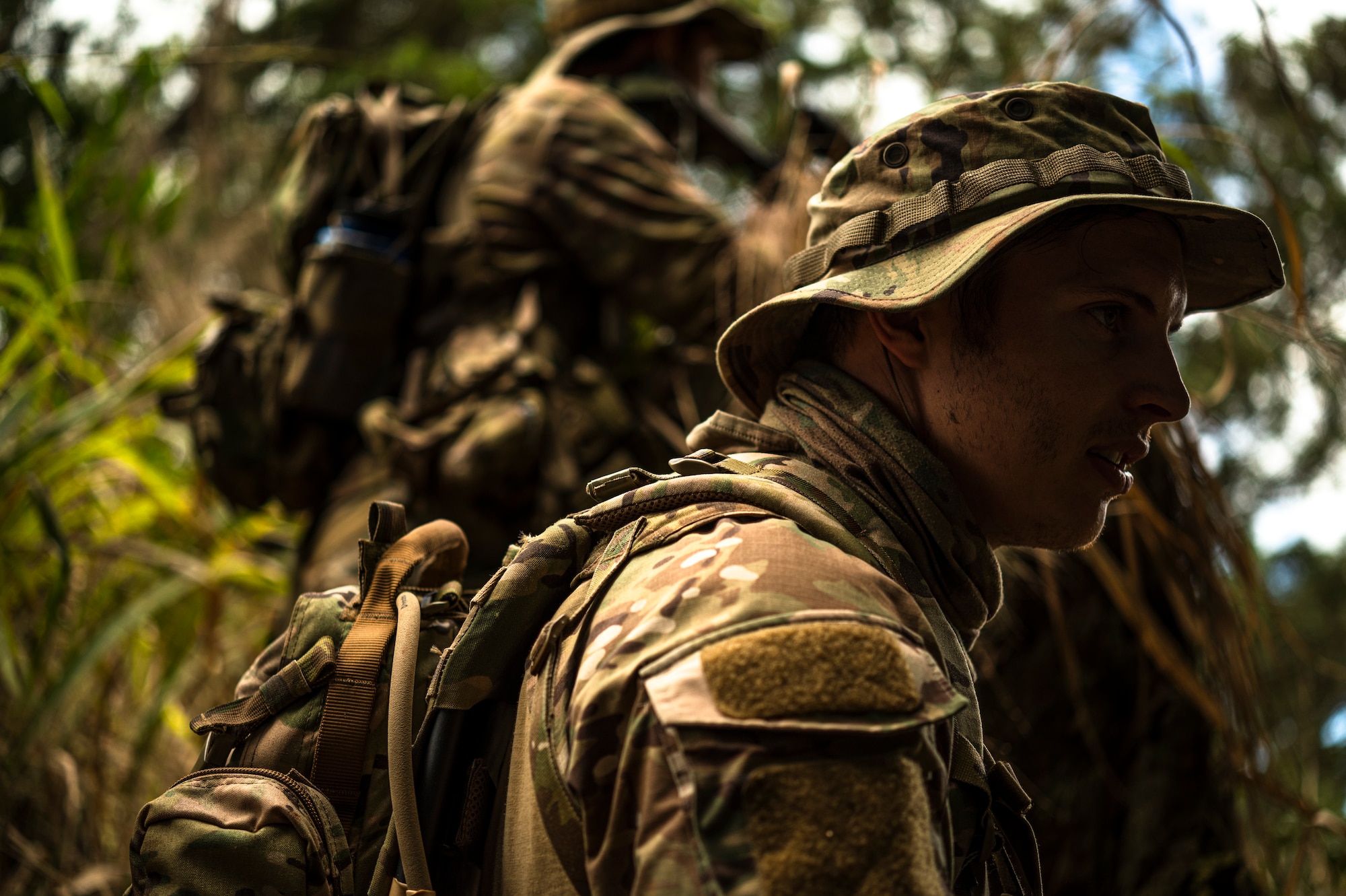 Photo of Airmen walking through jungle