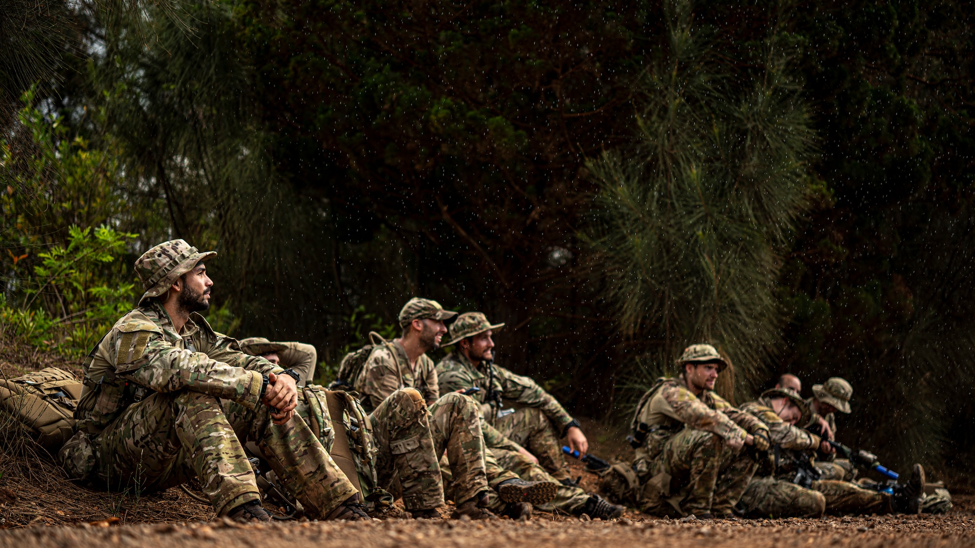 Photo of Airmen sitting on the side of a dirt road