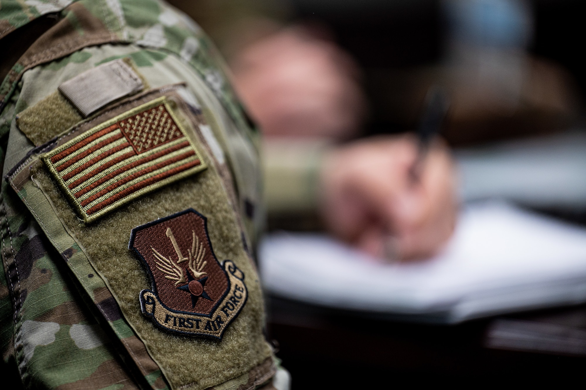 U.S. Air Force Col. Christopher Dinote, First Air Force-Air Forces Northern director of intelligence, surveillance, and reconnaissance, writes notes during a meeting at Goodfellow Air Force Base, Texas, April 1, 2022. The meeting focused on streamlining training within the 17th Training Group to create stronger interoperability between intelligence, cyber, and space professionals. (U.S. Air Force photo by Senior Airman Michael Bowman)