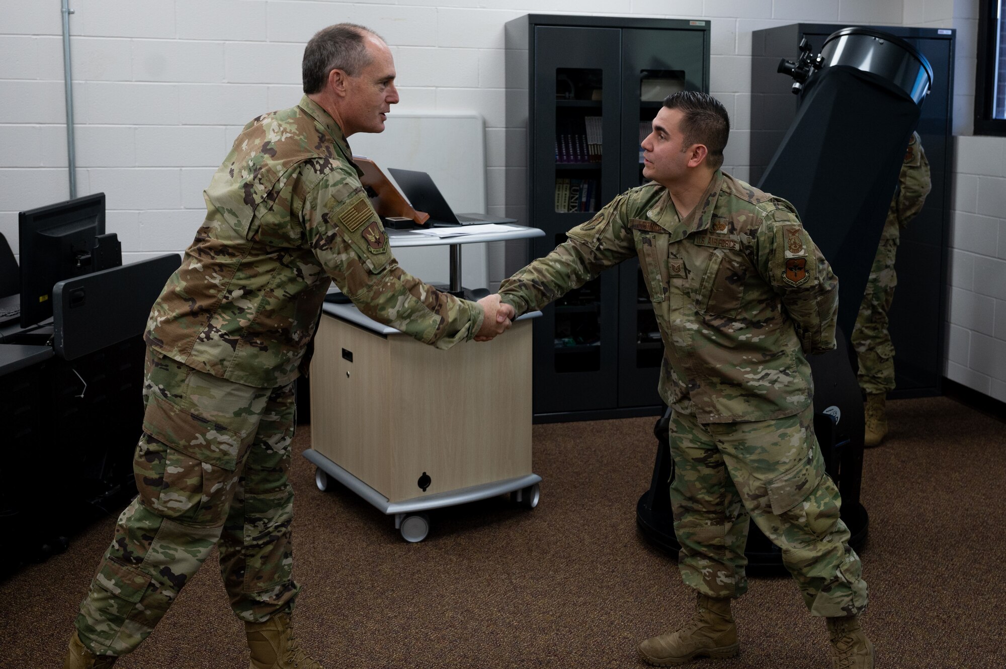 U.S. Air Force Lt. Gen. Kirk S. Pierce, Continental U.S. North American Aerospace Defense Command Region and 1st Air Force commander, congratulates Tech. Sgt. Joshua Leonida, 312th Training Squadron instructor supervisor at Goodfellow Air Force Base, Texas, April 1, 2022. Pierce coined Leonida for his exceptional performance. (U.S. Air Force photo by Senior Airman Michael Bowman)