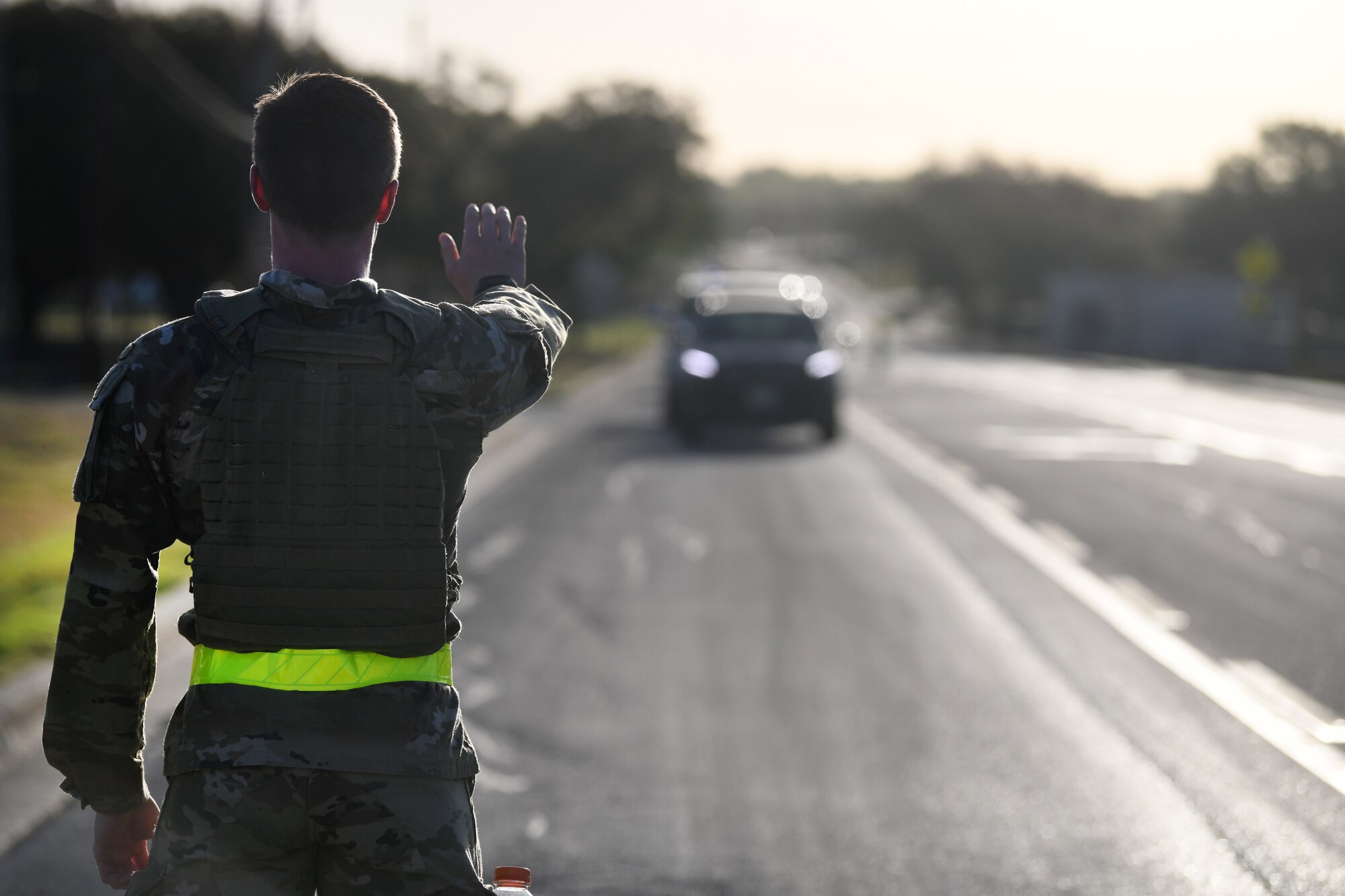 Special Warfare Trainees stop traffic during the Special Warfare Training Wing rededication ceremony in honor of U.S. Air Force Lt. Col. William Schroeder and U.S. Air Force Staff Sgt. Scott Sather at the SWTW training compound Joint Base San Antonio, Chapman Training Annex, Apr. 8, 2022. The wing hosted a two and one-half mile ruck march followed by Memorial pushups and the unveiling of refitted memorials in coordination with Gold Star families.  (U.S. Air Force photo by Brian Boisvert)