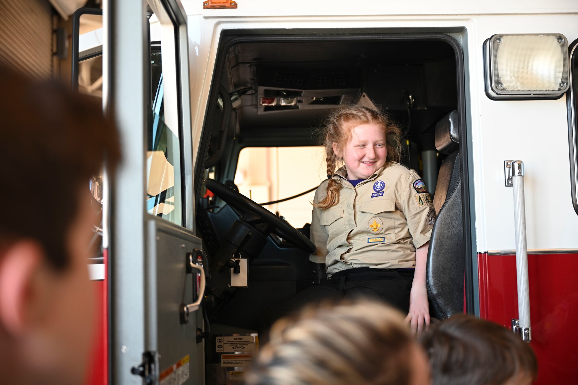 A troop from Scout Troop BSA 4434 takes her seat in one of 49th Civil Engineer Squadrons fire engines, during a tour of Fire Station 1, April 1, 2022, on Holloman Air Force Base, New Mexico. Events such as base tours are key to strengthening the relationship between Holloman and the surrounding community. (U.S. Air Force photo by Airman 1st Class Antonio Salfran)