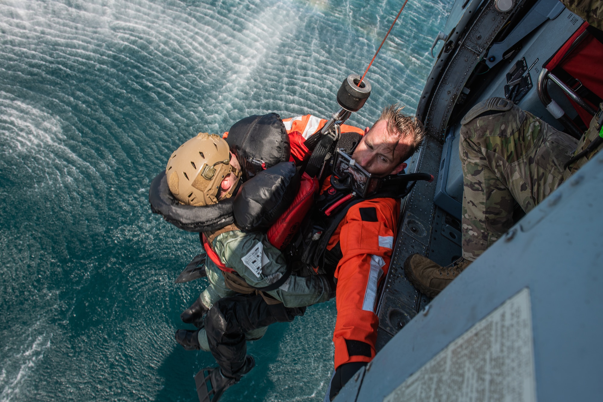 Naval Aircrewman (Helicopter) 1st Class Joshua Armitage, Helicopter Sea Combat Squadron 85 rescue swimmer, performs an open-sea rescue on Staff Sgt. Ahron Rasabi, 51st Operations Support Squadron survival, evasion, resistance and escape specialist, during a combat search and rescue training event April 8, 2022 over the Pacific Ocean.