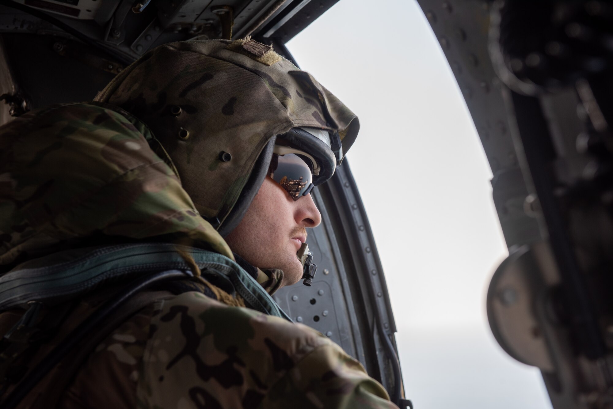 Naval Aircrewman (Helicopter) 1st Class Ryan Kuiper, Helicopter Sea Combat Squadron 85 crew chief, scans the horizon during a combat search and rescue (CSAR) training event April 8, 2022 over the Pacific Ocean.