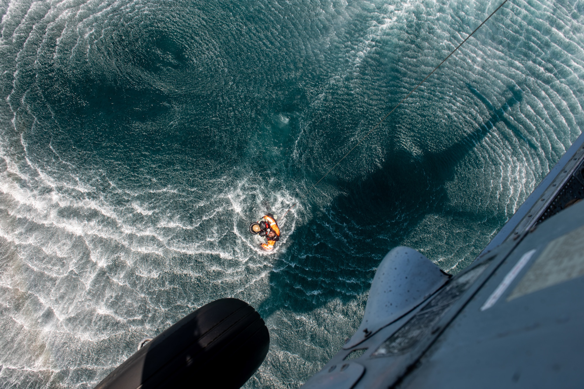 Naval Aircrewman (Helicopter) 1st Class Joshua Armitage, Helicopter Sea Combat Squadron 85 rescue swimmer, performs an open-sea rescue on Staff Sgt. Ahron Rasabi, 51st Operations Support Squadron survival, evasion, resistance and escape specialist, during a combat search and rescue training event April 8, 2022 over the Pacific Ocean.