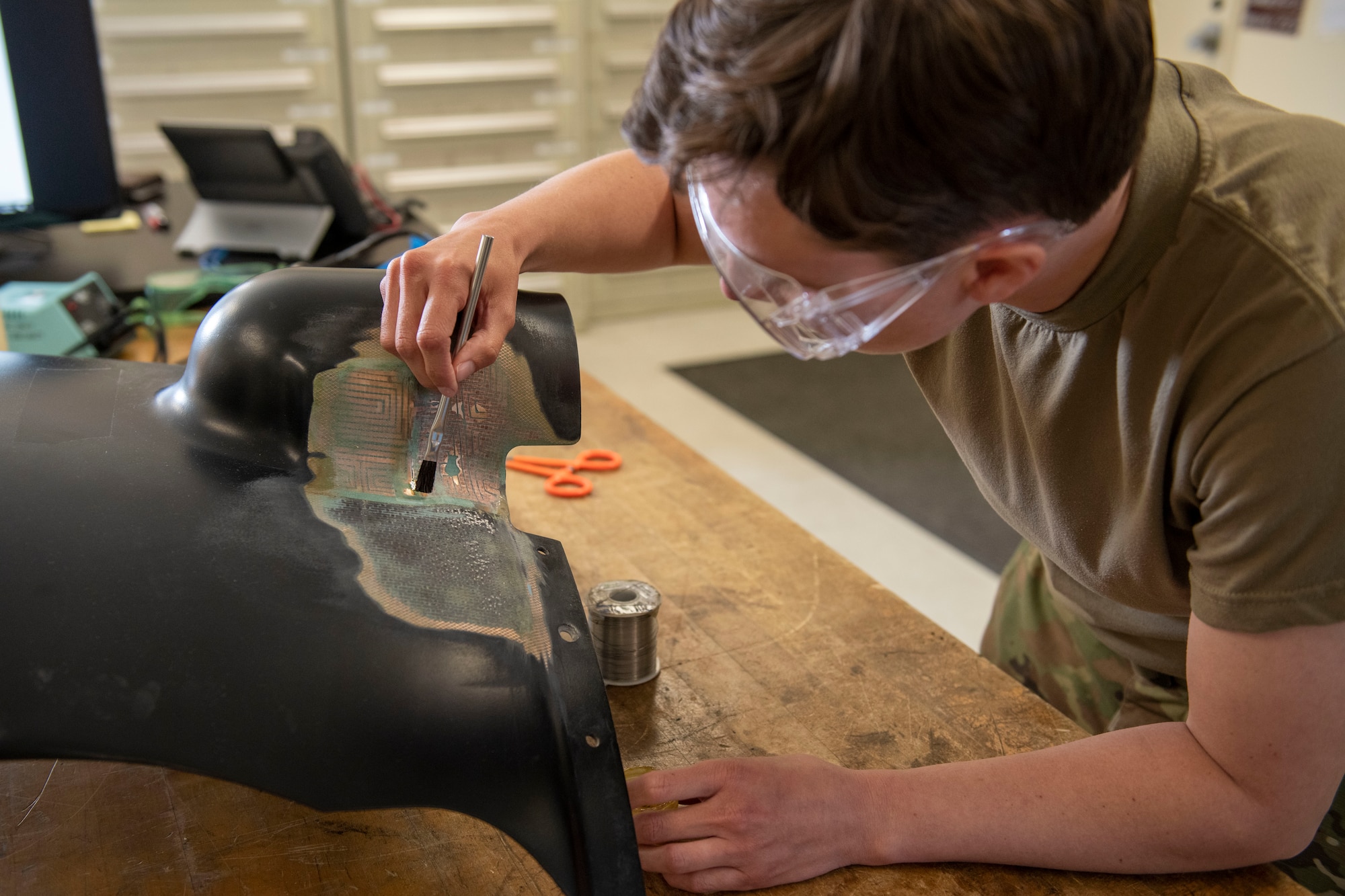 Senior Airman Sarah O’Shea, 374th Maintenance Squadron electrical and environmental systems journeyman, cleans a heat blanket on a CV-22 Osprey spinner panel at Yokota Air Base, Japan, April 6, 2022. The heat blanket functions to de-ice CV-22 engines. (U.S. Air Force photo by Senior Airman Hannah Bean)