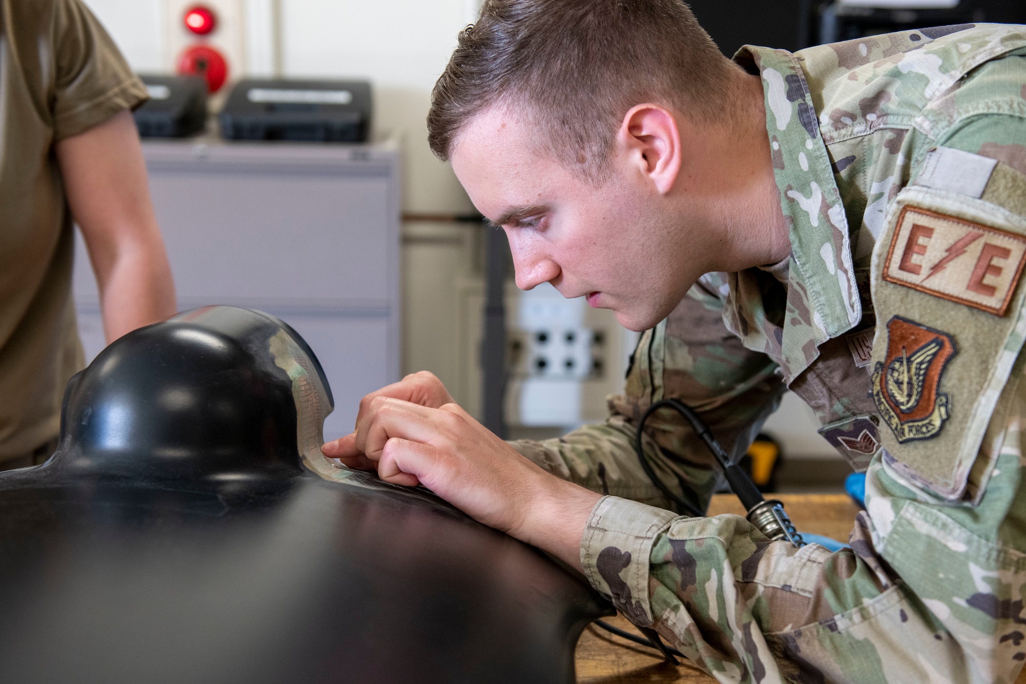Staff Sgt. Cameron Lachney, 374th Maintenance Squadron electrical and environmental systems craftsman, inspects a heat blanket on a CV-22 Osprey spinner panel at Yokota Air Base, Japan, April 6, 2022. The electrical and environmental shop performed the first ever patch repair on CV-22 Osprey spinner panel heat blanket in the Department of Defense. (U.S. Air Force photo by Senior Airman Hannah Bean)