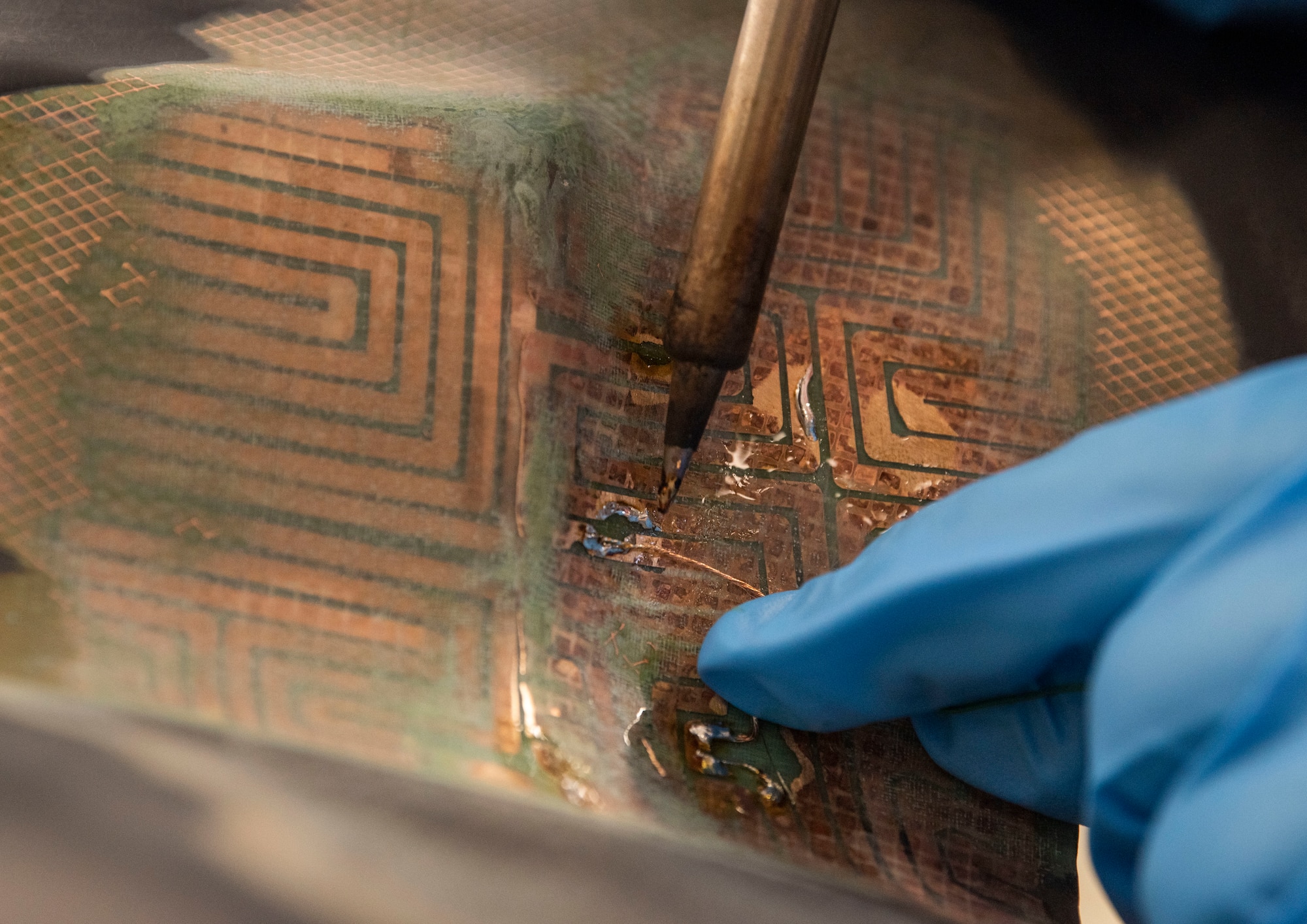 Staff Sgt. Cameron Lachney, 374th Maintenance Squadron electrical and environmental systems craftsman, solders a CV-22 Osprey heat blanket at Yokota Air Base, Japan, April 6, 2022. The electrical and environmental shop performed the first ever patch repair on CV-22 Osprey spinner panel heat blanket in the Department of Defense. (U.S. Air Force photo by Senior Airman Hannah Bean)