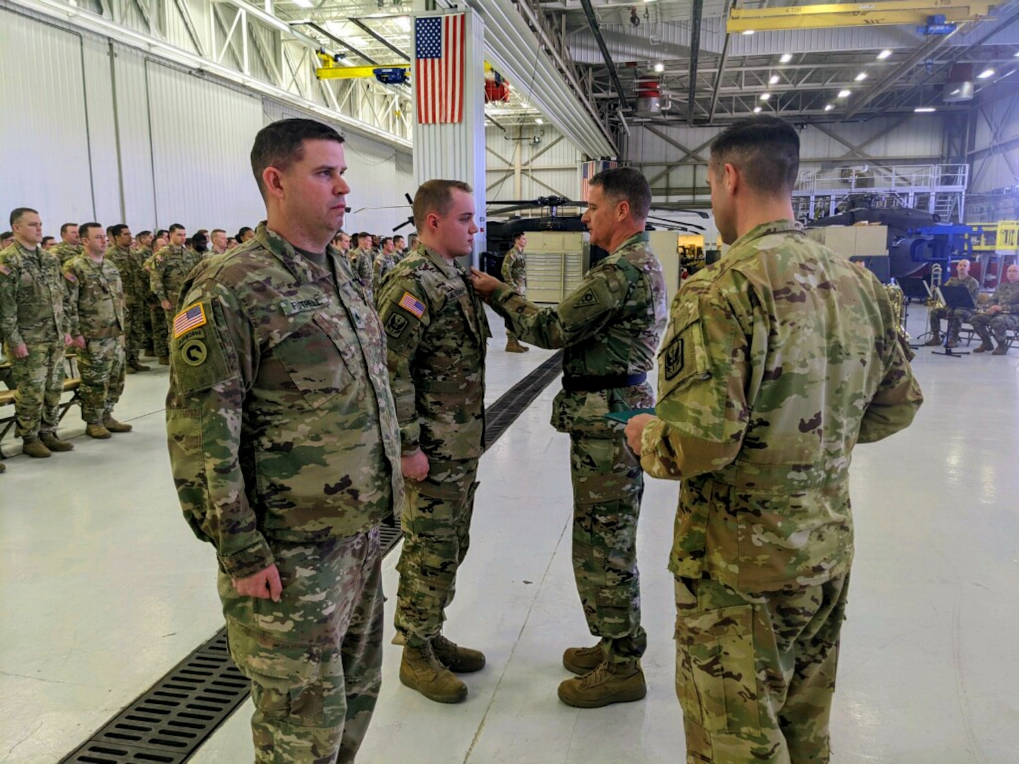 Ohio Army National Guard Brig. Gen. Stephen Rhoades, center, commander of Special Troops Command (Provisional), pins the Purple Heart on Sgt. Tristan Meyers April 10, 2022, during a ceremony at the Army Aviation Support Facility #1 in North Canton, Ohio. Meyers was among U.S. service members injured during a missile attack Jan. 8, 2020, at Al Asad Airbase, Iraq.