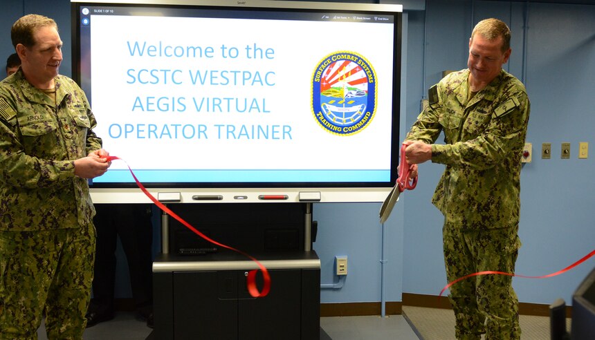 YOKOSUKA, Japan (April 08, 2022) Rear Adm. Erik Eslich (right), deputy commander, U.S. 7th Fleet, and Lt. Cmdr. Michael Arnold (left), officer-in-charge, Surface Combat Systems Training Command (SCSTC) Detachment Western Pacific (WESTPAC), cut the ribbon to unveil SCSTC’s new AEGIS Weapon System Virtual Operator Trainer (VOT) during a ribbon cutting ceremony onboard Commander, Fleet Activities Yokosuka, April 8.  (U.S. Navy photo by Patrick Ciccarone)