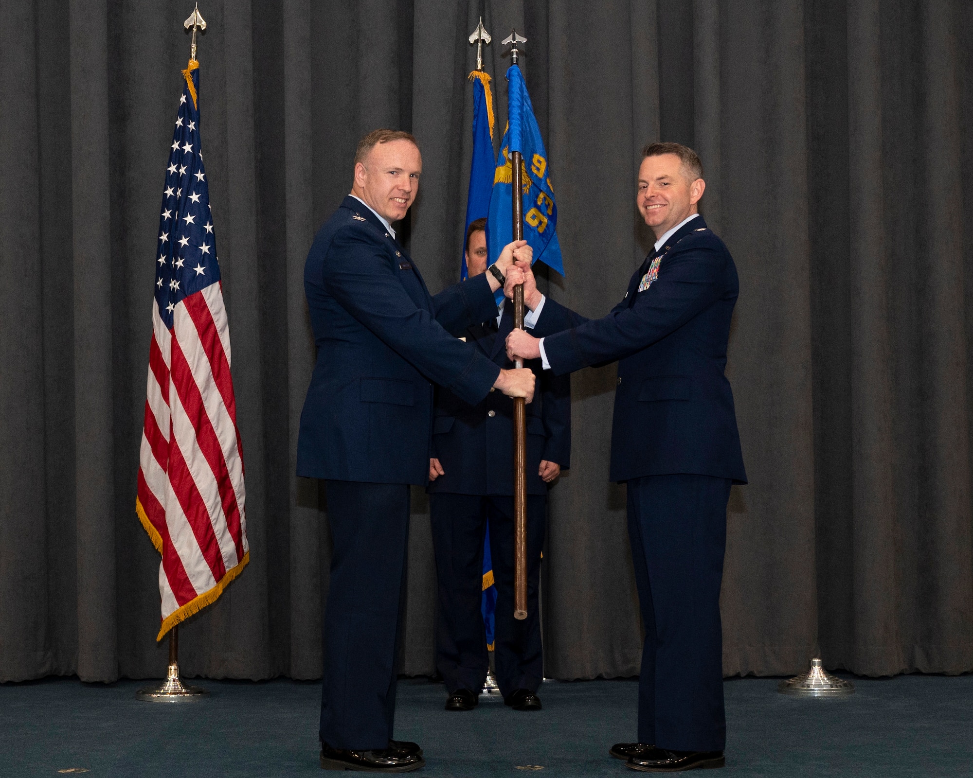 Two Airman hold a flag
