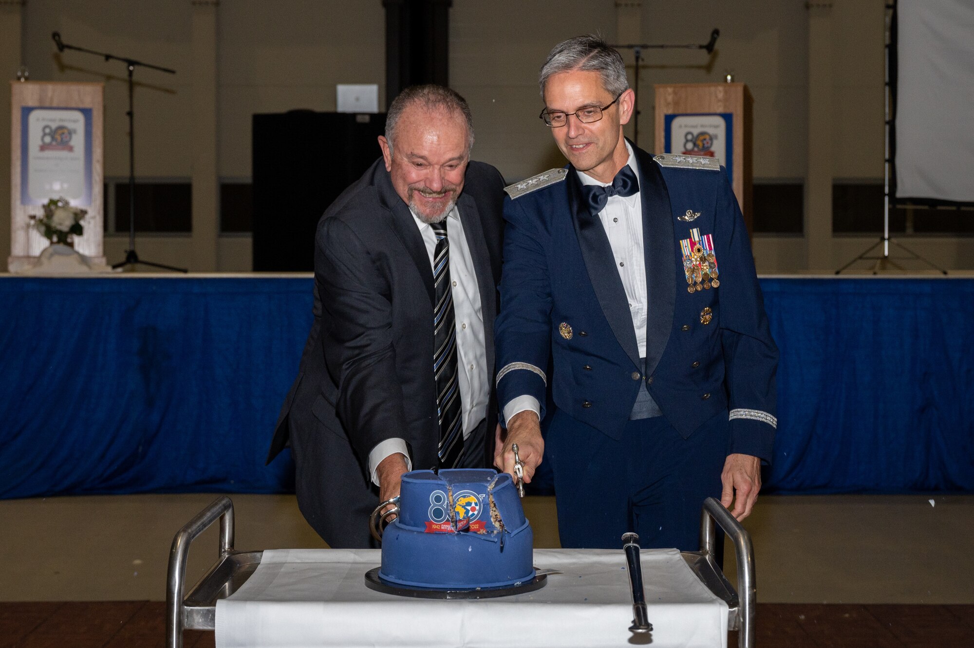 Two individuals cutting a cake.