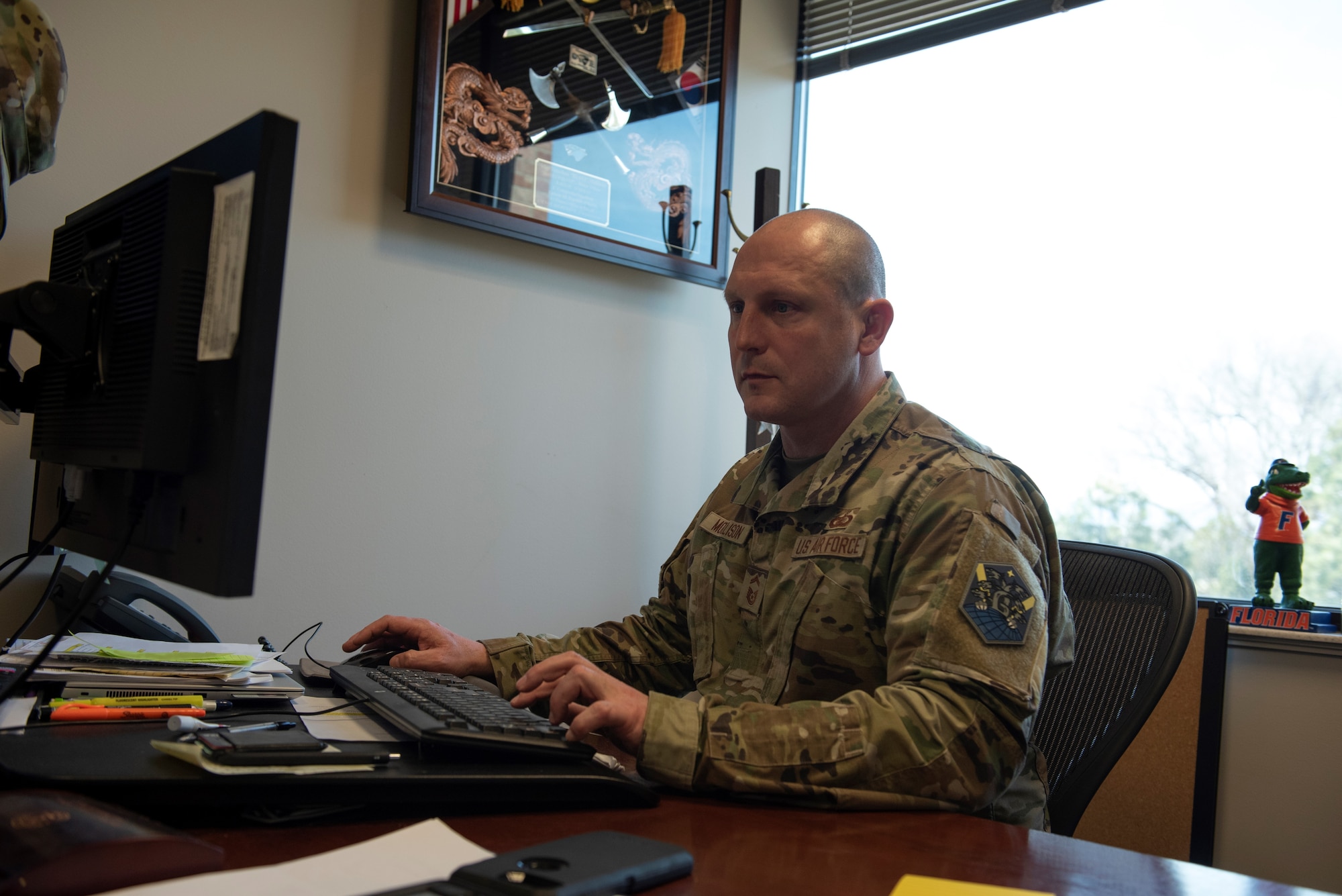 PETERSON SPACE FORCE BASE, Colo. – U.S. Air Force Senior Master Sgt. Johnathan Mollison, 21st comptroller squadron senior enlisted leader, works on his computer at Peterson Space Force Base, Colorado, March 18, 2022. The 21st CPTS mission is to push resources to space warfighters – financing unsurpassed installation support while providing combat ready warriors to defend America and its Allies. (This photo has been altered for security purposes by covering written information on papers.) (U.S. Space Force photo by Master Sgt. Tabitha Lee.)