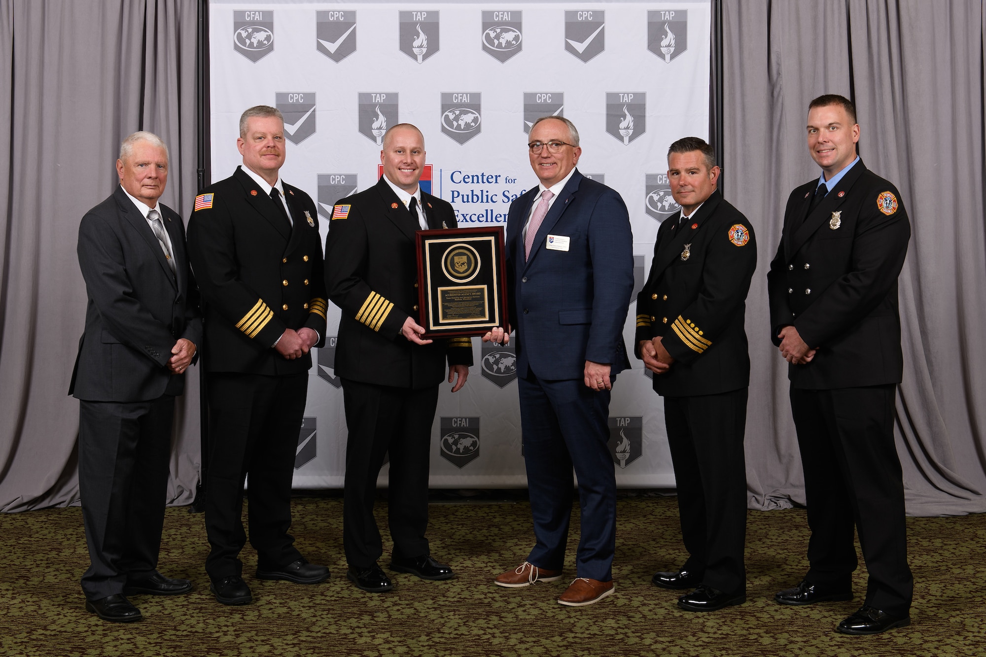 Chief Fire Officer Steven Dirksen, chair of the Commission on Fire Accreditation International presents a plaque to the Truax Field Fire and Emergency Services leadership team upon their department’s accreditation by the organization in Orlando, Florida, March 23, 2022.