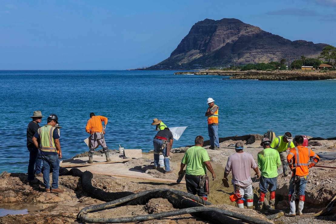 Naval Sea Systems Command (NAVSEA) contractors pour concrete during the final phase of an equipment removal project at Nanakuli Beach Park.