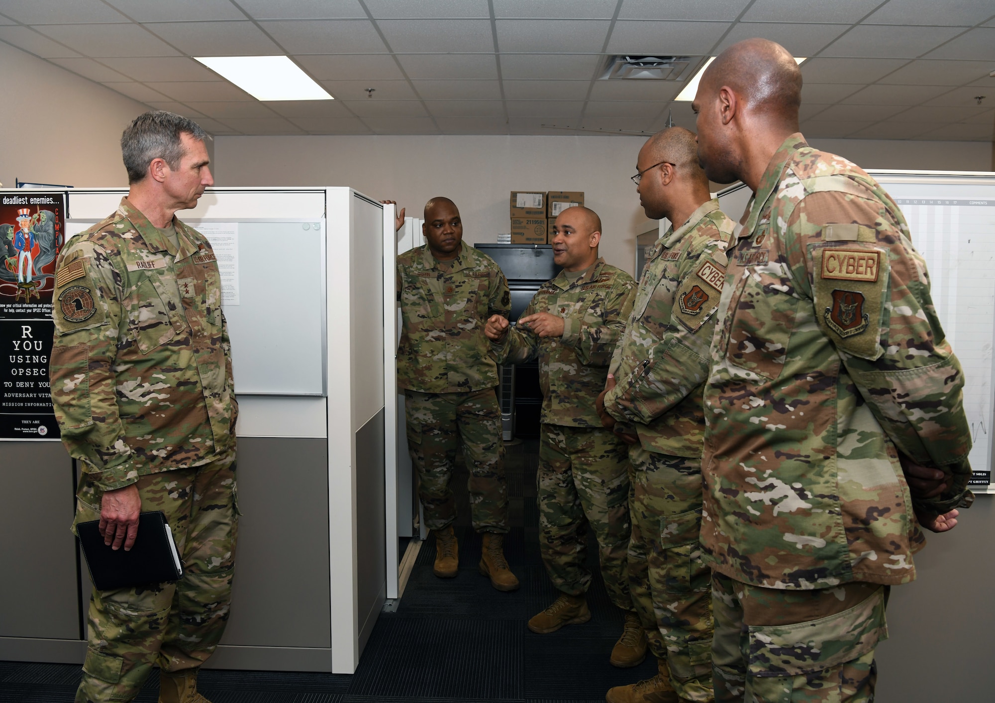 Maj. Rhenso Hernandez, 854th Combat Operations Squadron division chief (center), talks to Maj. Gen. Bryan P. Radliff, 10th Air Force commander, about the wing's mission April 2, 2022, at Joint Base San Antonio-Chapman Training Annex, Texas. Radliff visited several units within the 960th Cyberspace Wing during the visit. (U.S. Air Force photo by Kristian Carter)