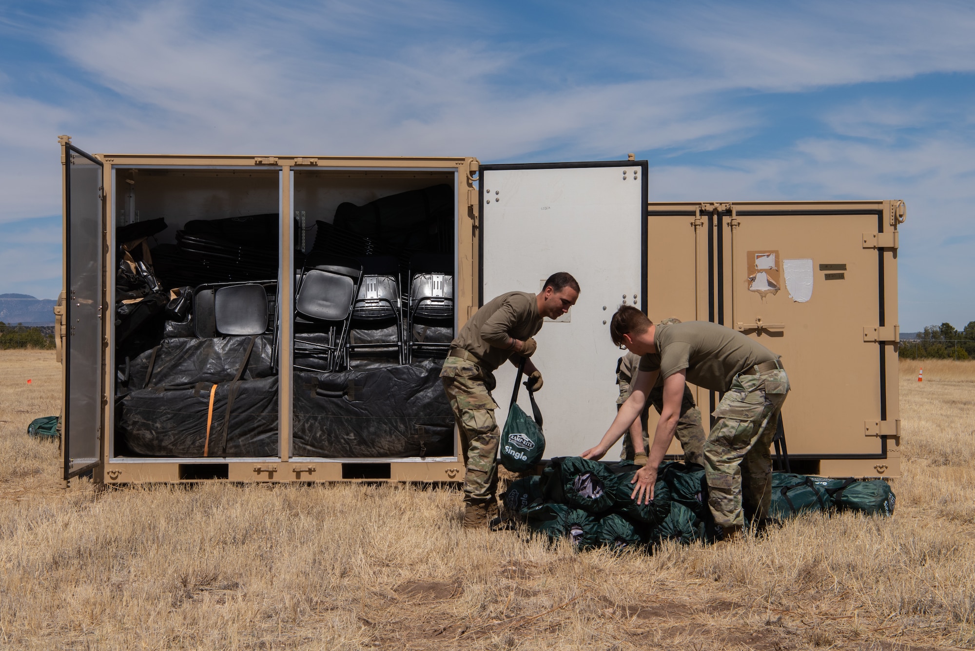 Two Air Commandos from the 27th Special Operations Mission Support Group, Detachment 1 Mission Sustainment Team 2 unload cot-sized mattress pads from a cargo container during the setup of their contingency location during the Full Mission Profile 22-3 exercise at Sierra Blanca Regional Airport, New Mexico. (U.S. Air Force photo by Airman 1st Class Alexis Sandoval)