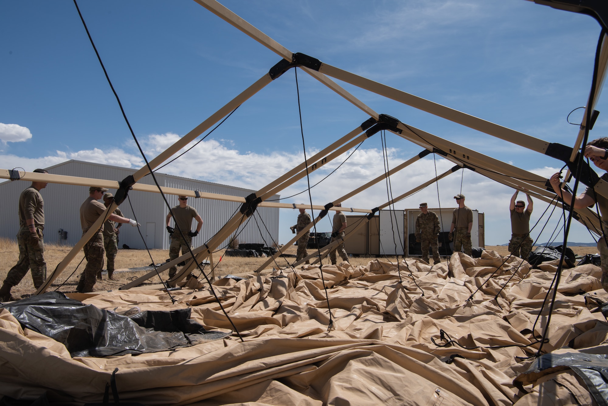 Air Commandos from the 27th Special Operations Mission Support Group, Detachment 1 Mission Sustainment Team 2 set use ropes and pulleys to pitch a Utilis TXL-80 tent at their contingency location during the Full Mission Profile 22-3 exercise at Sierra Blanca Regional Airport, New Mexico. (U.S. Air Force photo by Airman 1st Class Alexis Sandoval)
