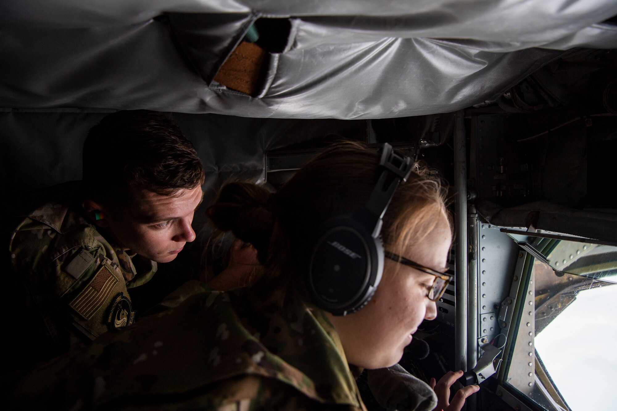 A cadet with Air Force ROTC Detachment 159 at the University of Central Florida observes Airman 1st Class Mackenzie Rodgers, a boom operator assigned to the 91st Air Refueling Squadron, prepare to refuel an aircraft over Texas, April 11, 2022.