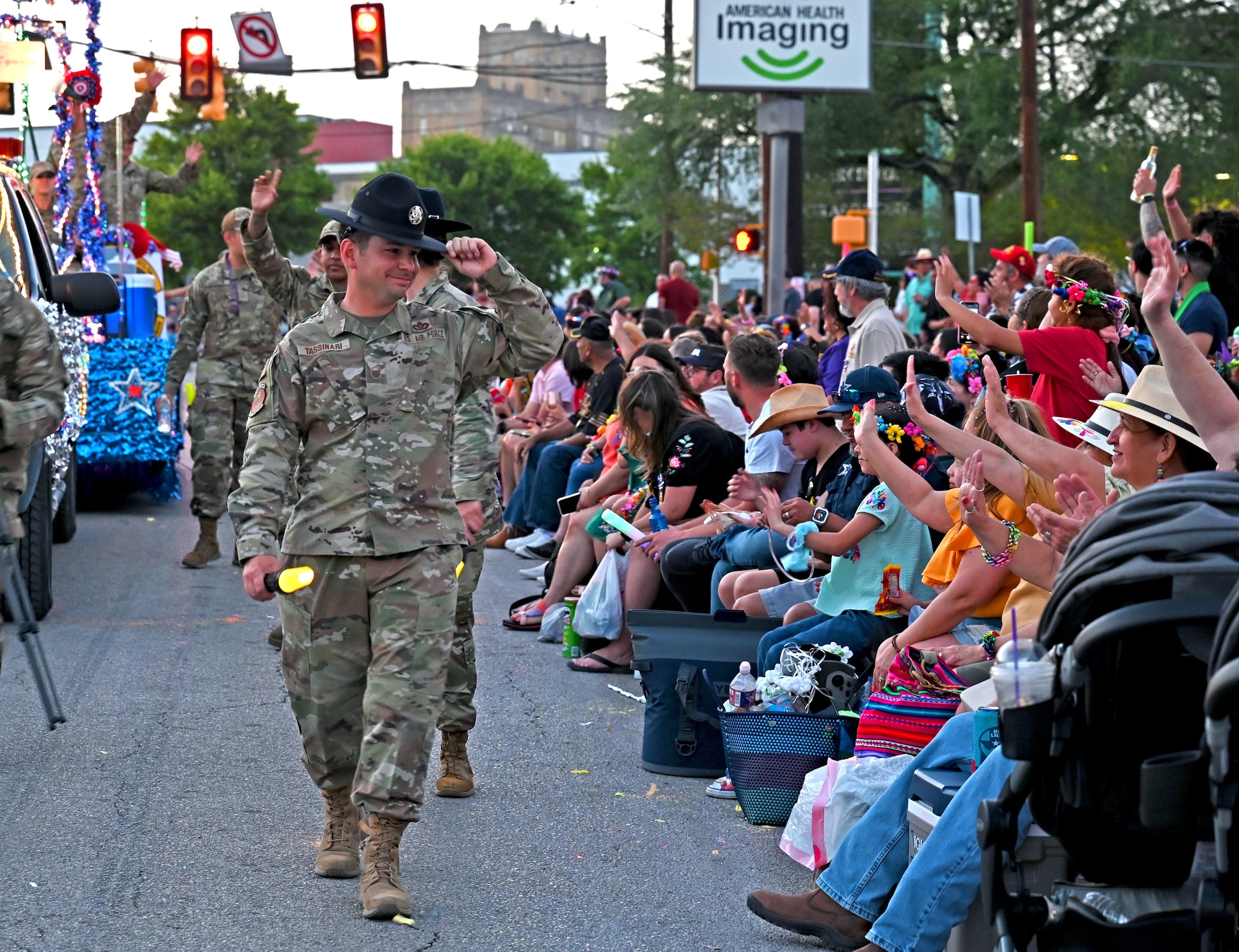 Master Sgt. Anthony Tassinari, 340th Flying Training Group military training instructor, greets the crowd while walking in San Antonio's 74th annual Fiesta Flambeau parade, April 9, 2022. The illuminated parade attracted over 750,000 spectators after a 2-year break following the COVID-19 lockdown and restrictions. (U.S. Air Force photo by Master Sgt. Samantha Mathison)