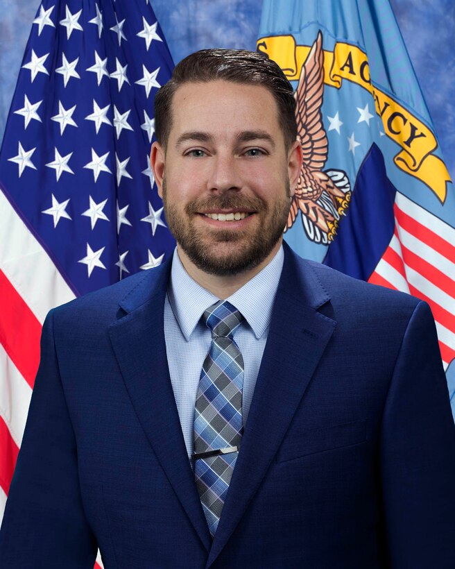 A man poses for an official agency portrait.