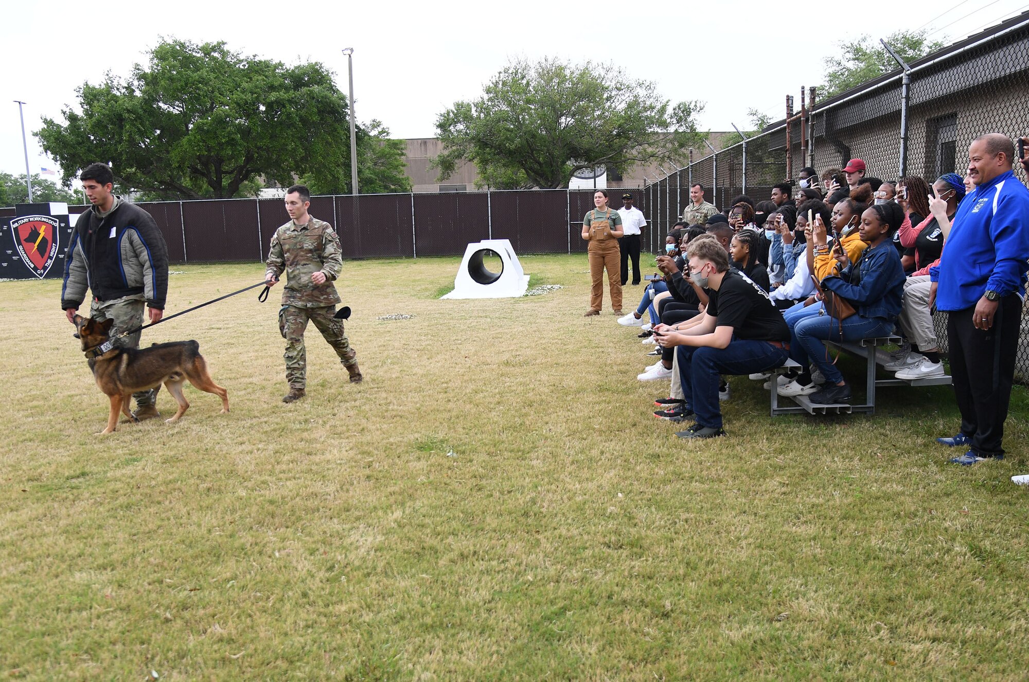 U.S. Air Force Senior Airman Anthony Seretis and Staff Sgt. Dustin Hadsock, 81st Security Forces Squadron military working dog handlers, and Rico, 81st SFS military working dog, provides a demonstration to Jefferson Davis County High School Junior ROTC cadets outside the kennel at Keesler Air Force Base, Mississippi, April 12, 2022. Throughout their visit to Keesler, more than 30 cadets also received a Hurricane Hunters briefing and visited air traffic control training courses. (U.S. Air Force photo by Kemberly Groue)