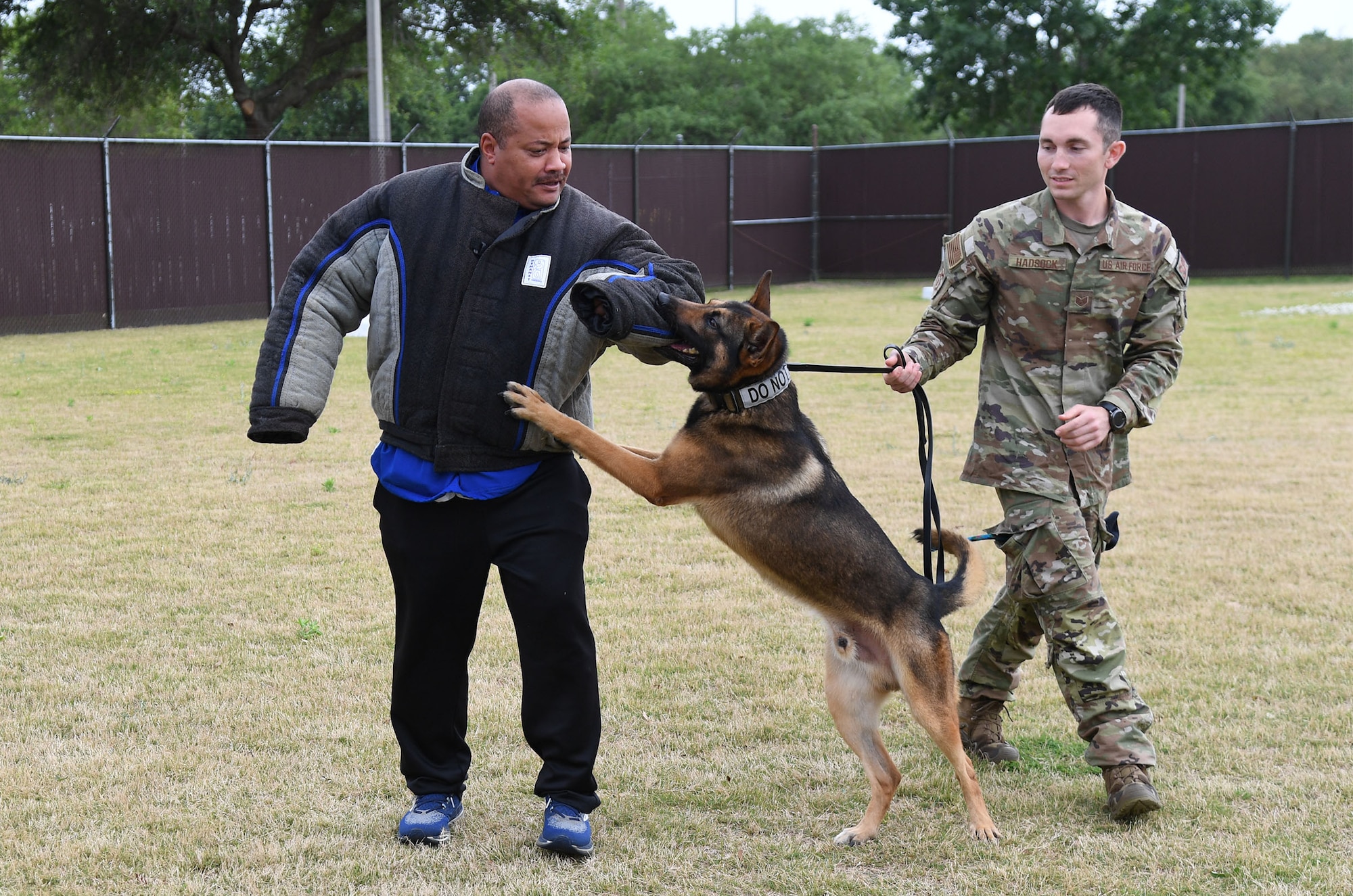 U.S. Air Force Staff Sgt. Dustin Hadsock, 81st Security Forces Squadron military working dog handler, Rico, 81st SFS military working dog, and retired U.S. Army Sgt. 1st Class Michael Turner, Jefferson Davis County High School Junior ROTC instructor, provides a demonstration to Jefferson Davis County High School Junior ROTC cadets outside the kennel at Keesler Air Force Base, Mississippi, April 12, 2022. Throughout their visit to Keesler, more than 30 cadets also received a Hurricane Hunters briefing and visited air traffic control training courses. (U.S. Air Force photo by Kemberly Groue)