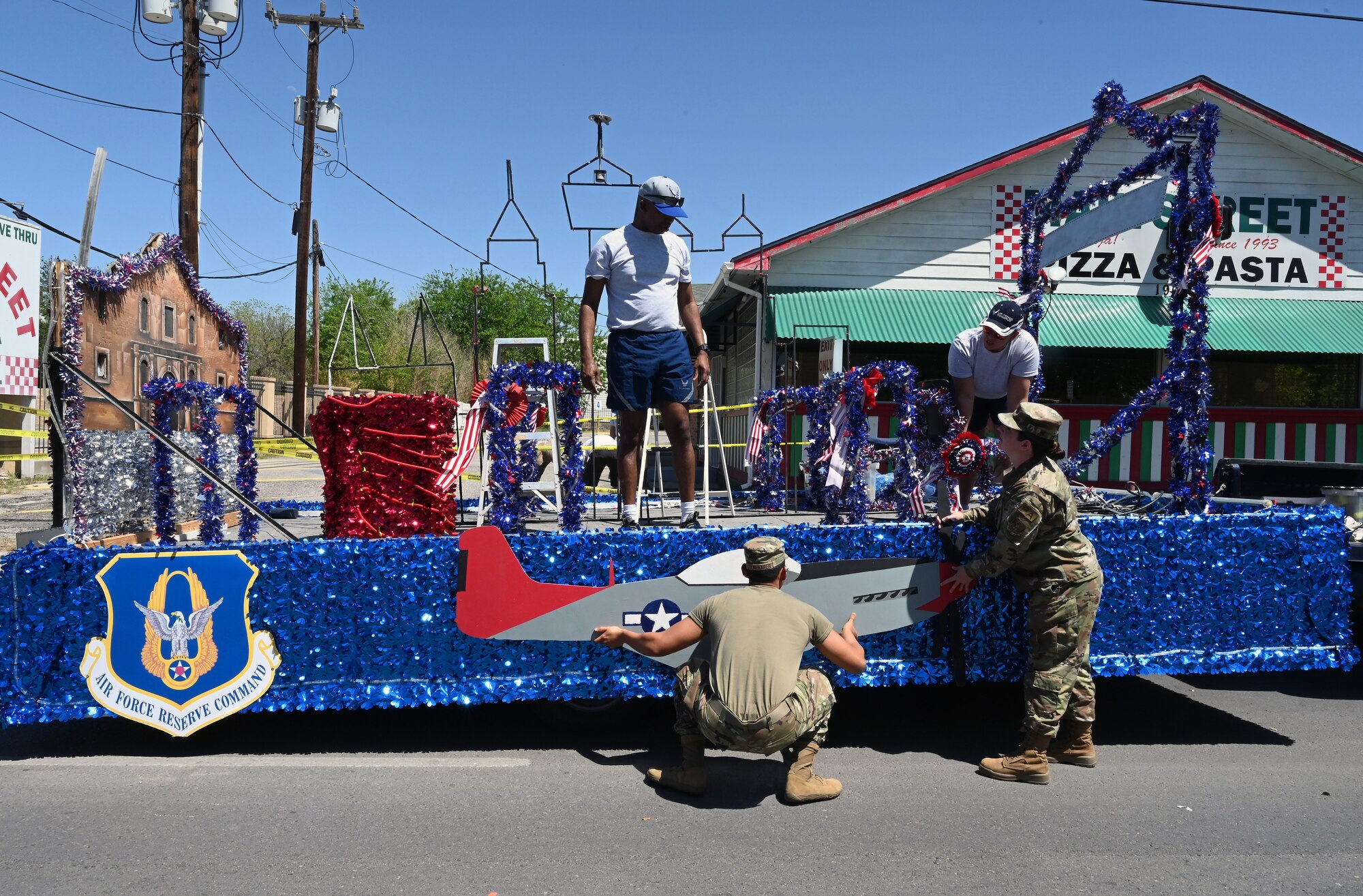Reserve Citizen Airmen in the 433rd Airlift Wing, 960th Cyberspace Wing, 340th Flying Training Group and 23rd Intelligence Squadron put the finishing touches on the float honoring Senior Master Sgt. James Bynum for the San Antonio Fiesta Flambeau parade April 9, 2022. Bynum, a local Tuskegee Airman who served during WWII, was not able to attend the parade due to unforeseen circumstances but was still highlighted for his service and legacy during the parade. (U.S. Air Force photo by Staff Sgt. Monet Villacorte)