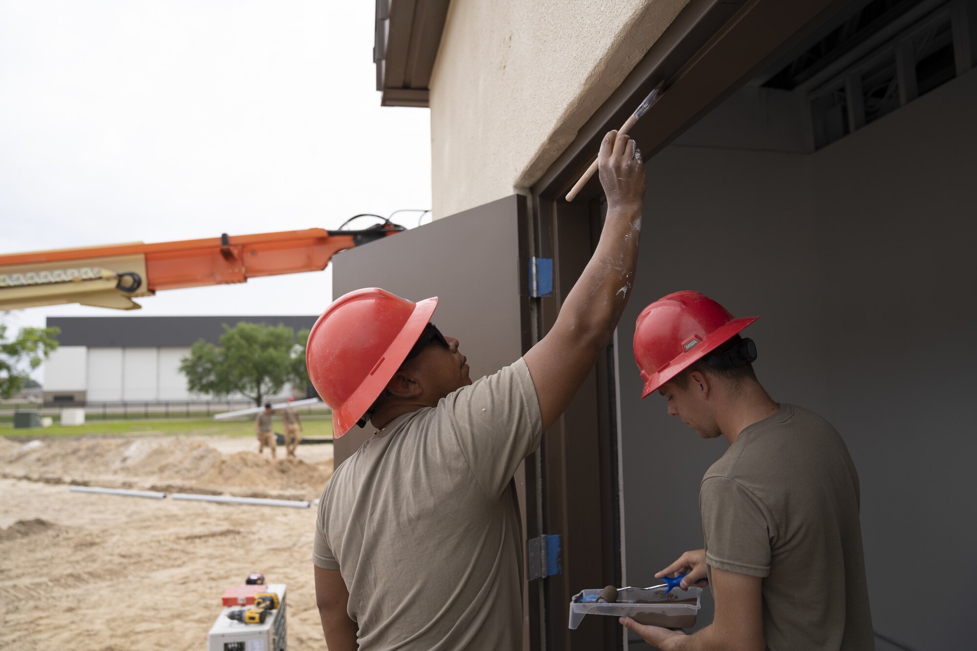 U.S. Air Force Staff Sgt. Sergio Quiroz and Dillon Mitchell, 823rd Rapid Engineer Deployable Heavy Operational Repair Squadron Engineer structural journeymen, paint a door frame at Keesler Air Force Base, Mississippi, April 13, 2022. The squadron is working to expand the Air Expeditionary Force compound to allow radio frequency transmissions and cyber transport courses increase efficiency in training. (U.S. Air Force photo by Airman 1st Class Trenten Walters)