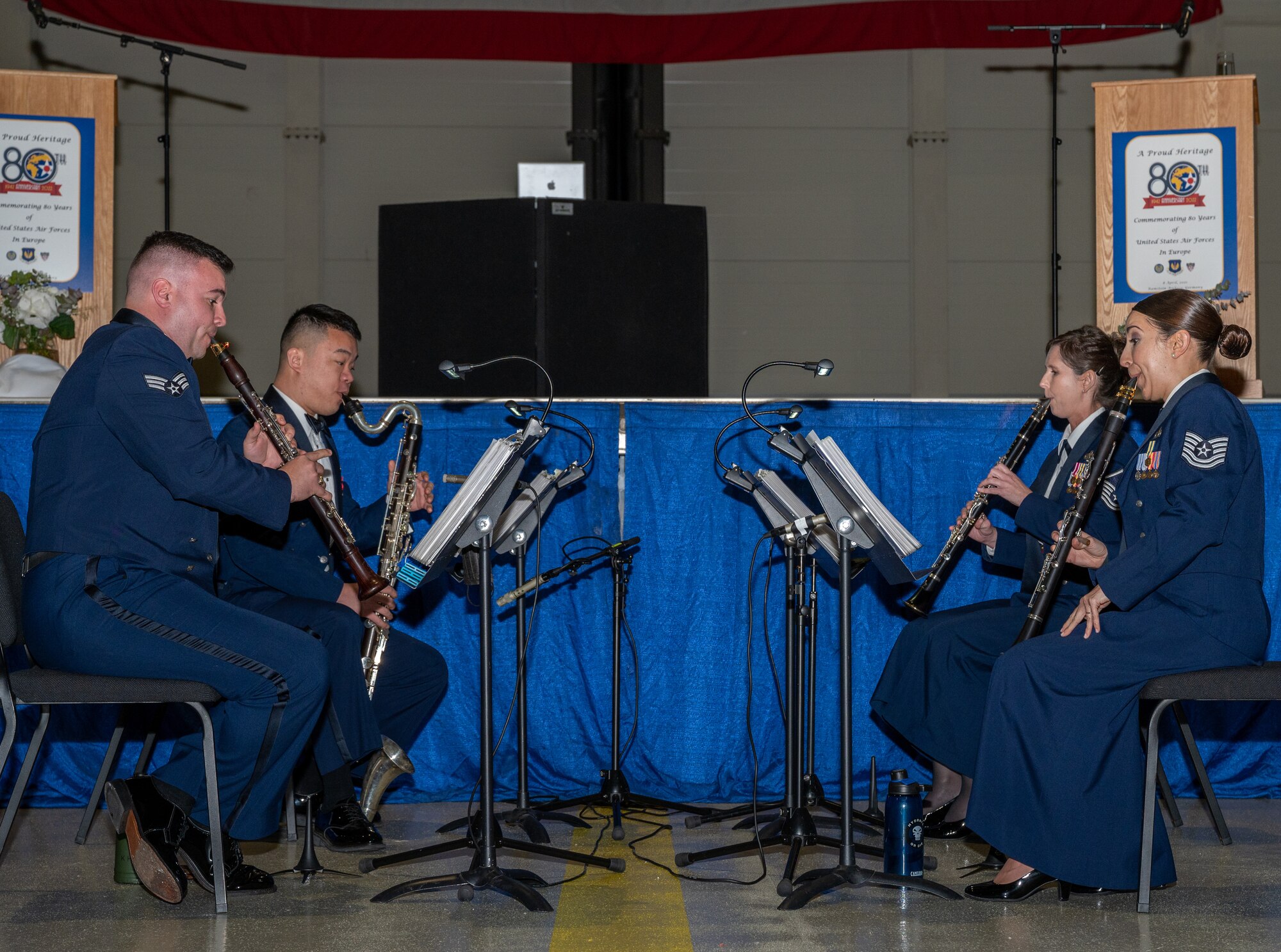 Four band members playing musical instruments.