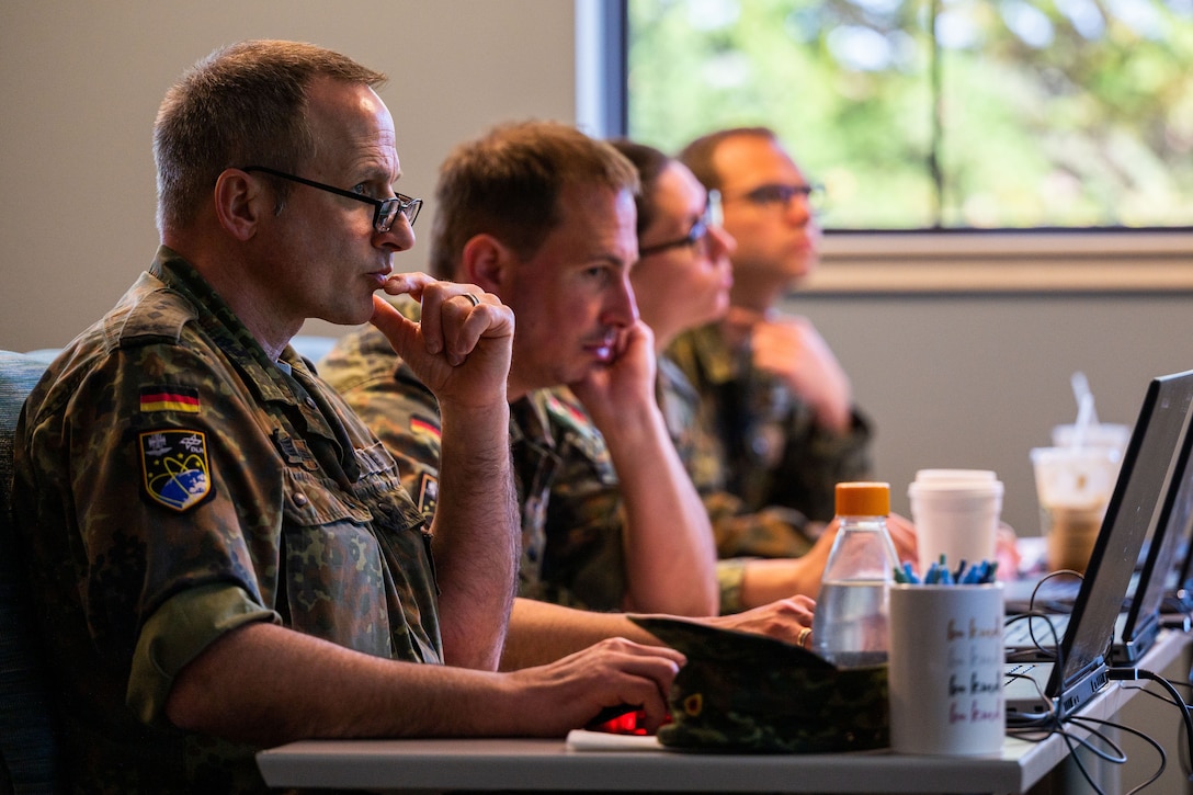 German space operators sitting at desk with laptop workstations