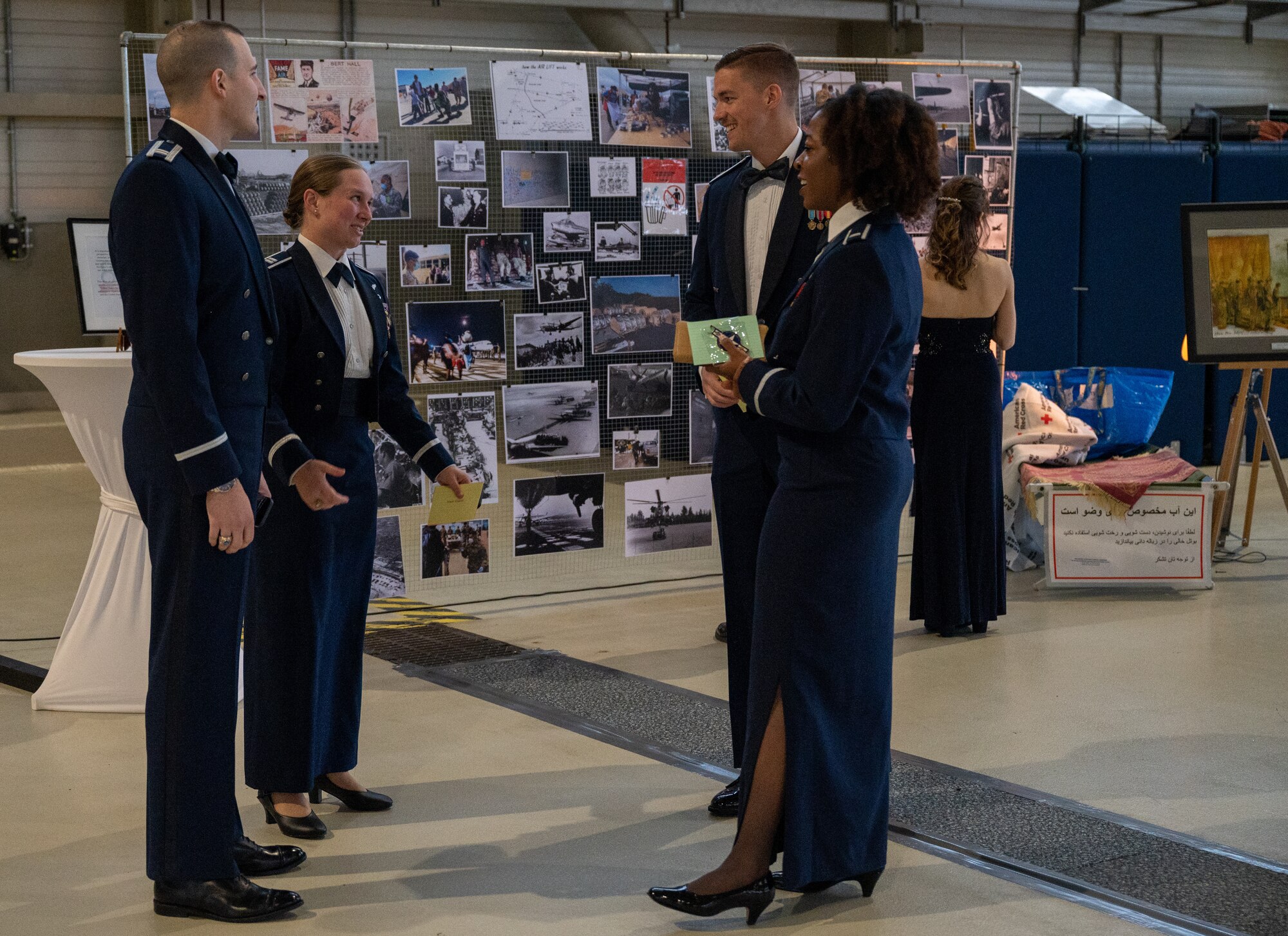 A group of individuals standing by a wall of photos.