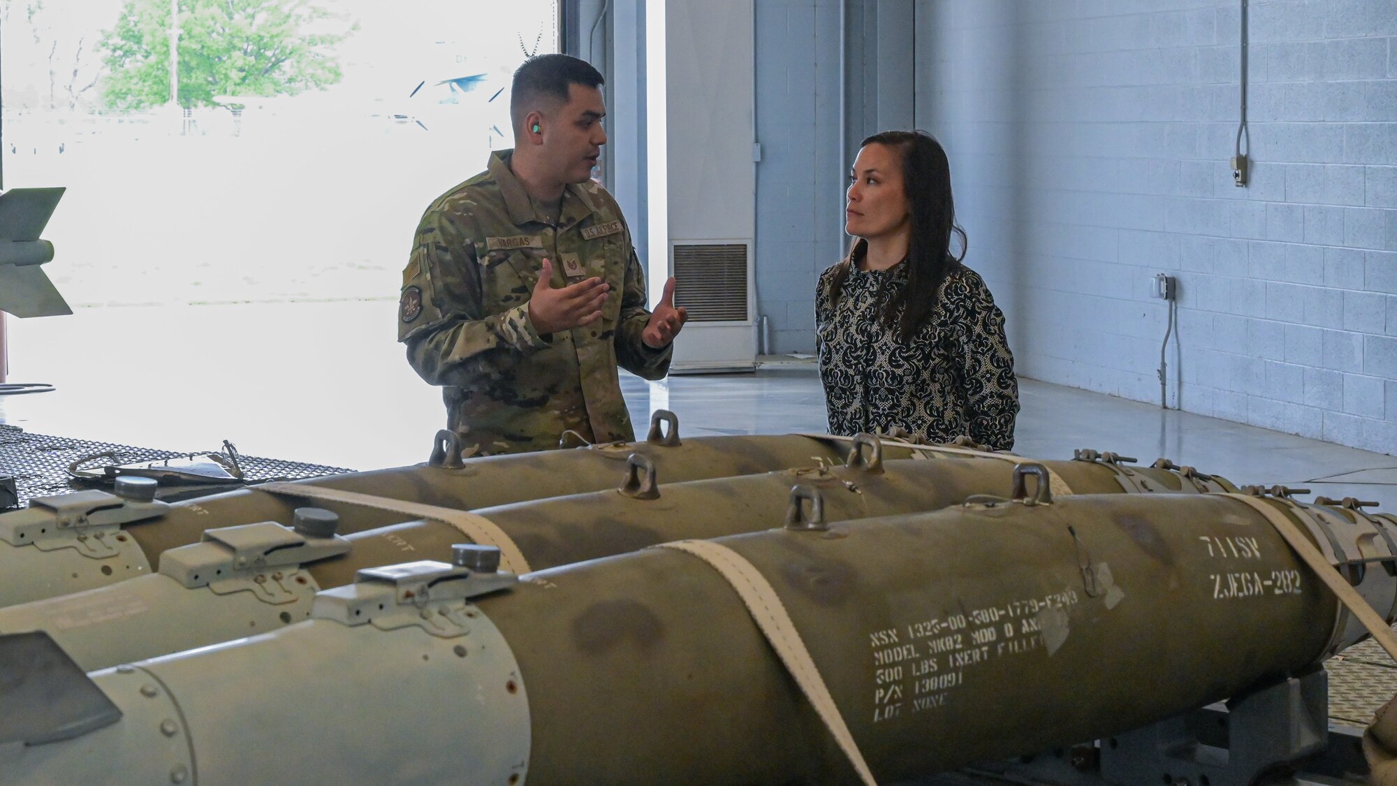 The Honorable Gina Ortiz Jones, Under Secretary of the Air Force, receives a brief by Tech. Sgt. Uriel Vargas from the 707th Maintenance Squadron at the Tech Sgt. Joshua Kidd’s Weapons Load Training Facility during a visit to Barksdale Air Force Base, Louisiana, April 12, 2022. Tech Sgt. Joshua Kidd’s Weapons Load Training Facility was named after Tech. Kidd, a 2nd Maintenance Group, loading standardization crew chief who was shot and killed outside of his house in Bossier City, Louisiana. (U.S. Air Force photo by Senior Airman Jonathan E. Ramos)