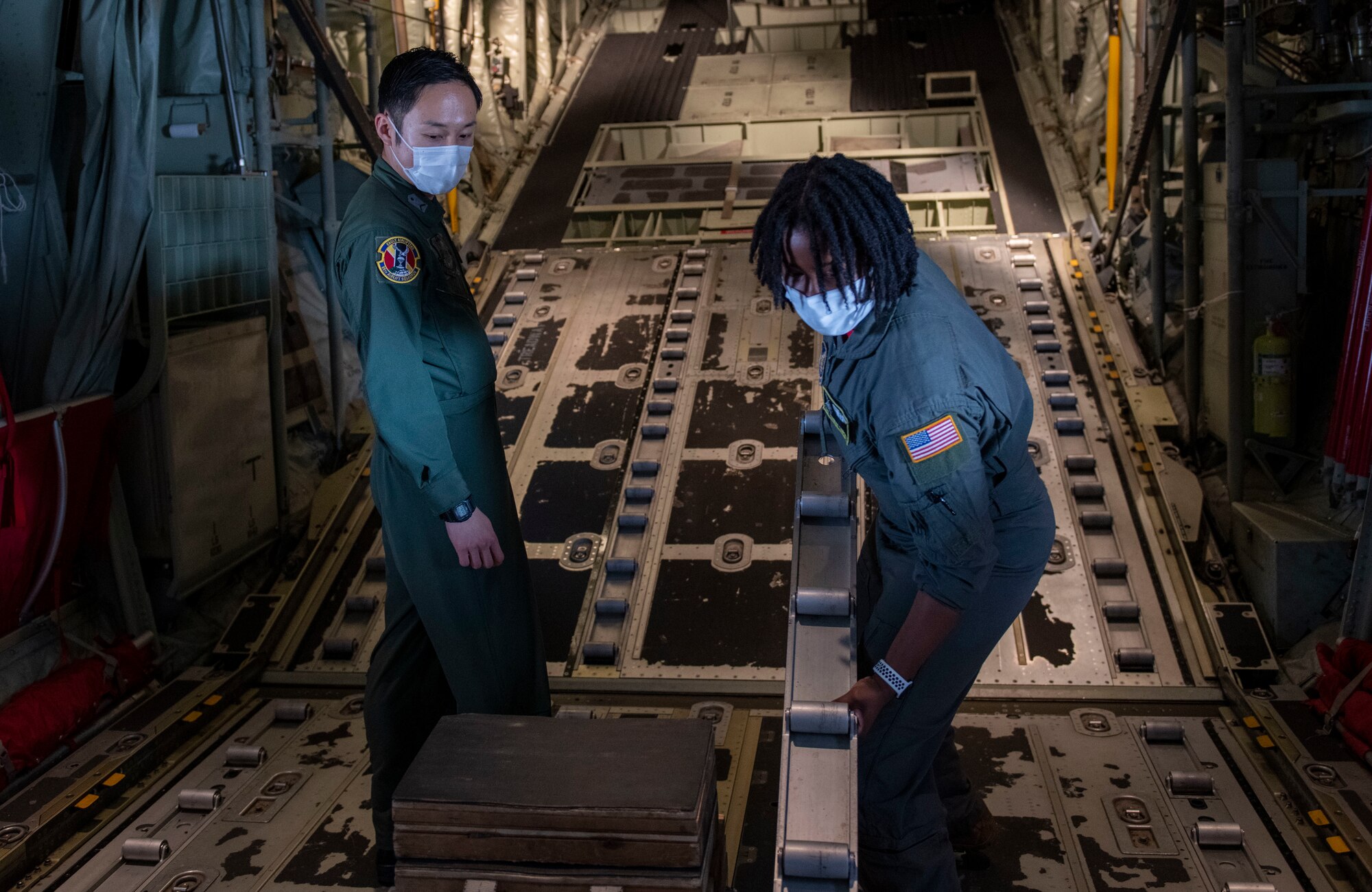 A U.S. Air Force Airman demonstrates the capabilities of a C-130J Super Hercules to a Japan Air Self-Defense Force member