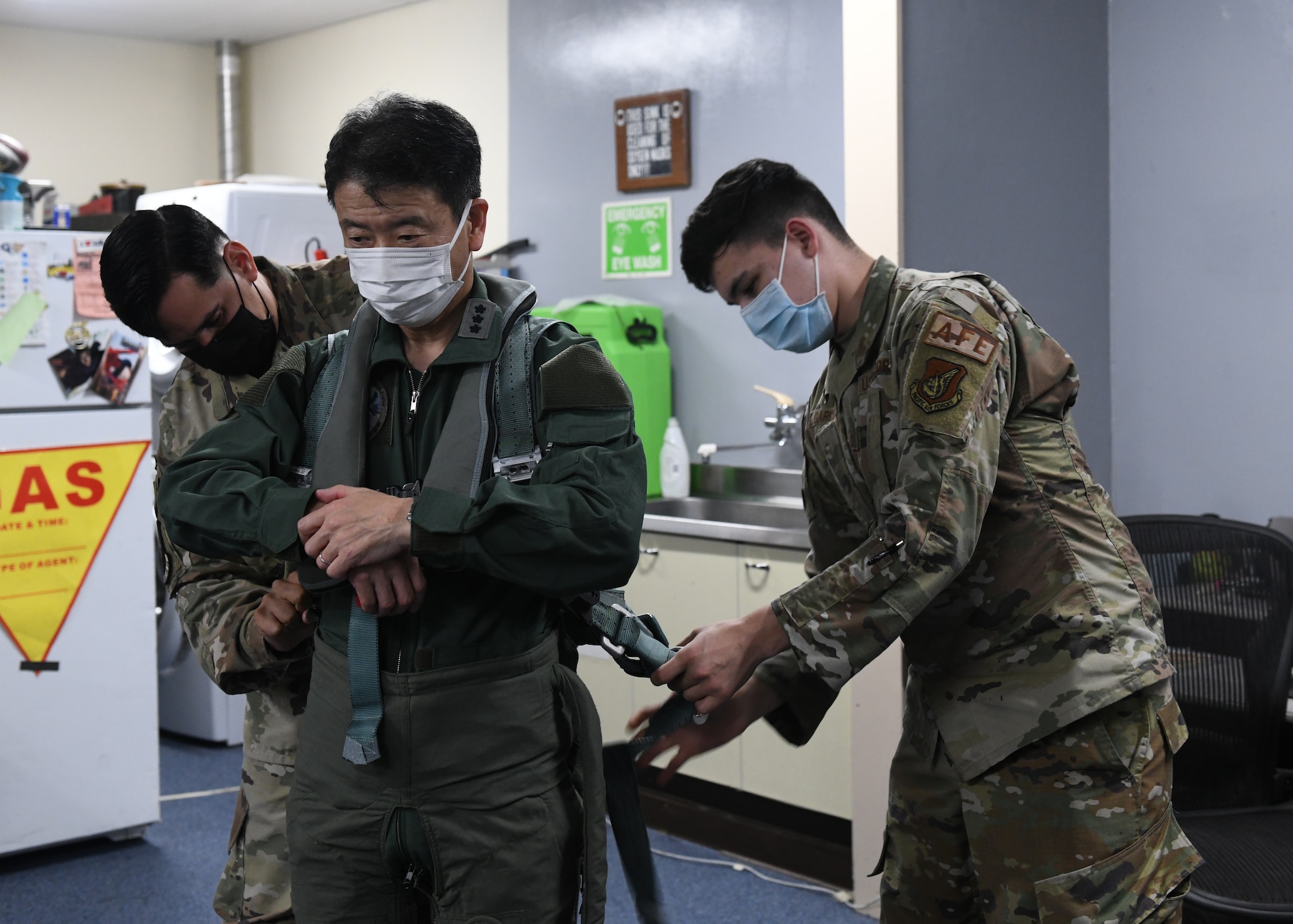 Aircrew flight equipment technicians assigned to the 18th Operations Support Squadron assist Japan Air Self-Defense Force Lt. Gen. Masahito Yajima, Southwestern Air Defense Force commander, in preparing for a familiarization flight at Kadena Air Base, Japan, April 12, 2022. Team Kadena Airmen routinely participate in training events and exercises with JASDF counterparts to strengthen interoperability, ensure the defense of Japan and maintain a free and open Indo-Pacific. (U.S. Air Force photo by Staff Sgt. Benjamin Raughton)